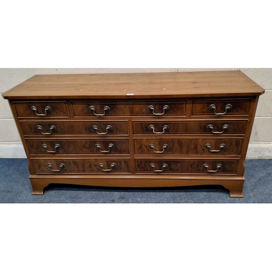 A REPRODUCTION YEWWOOD SIDEBOARD, fitted with nine assorted ...