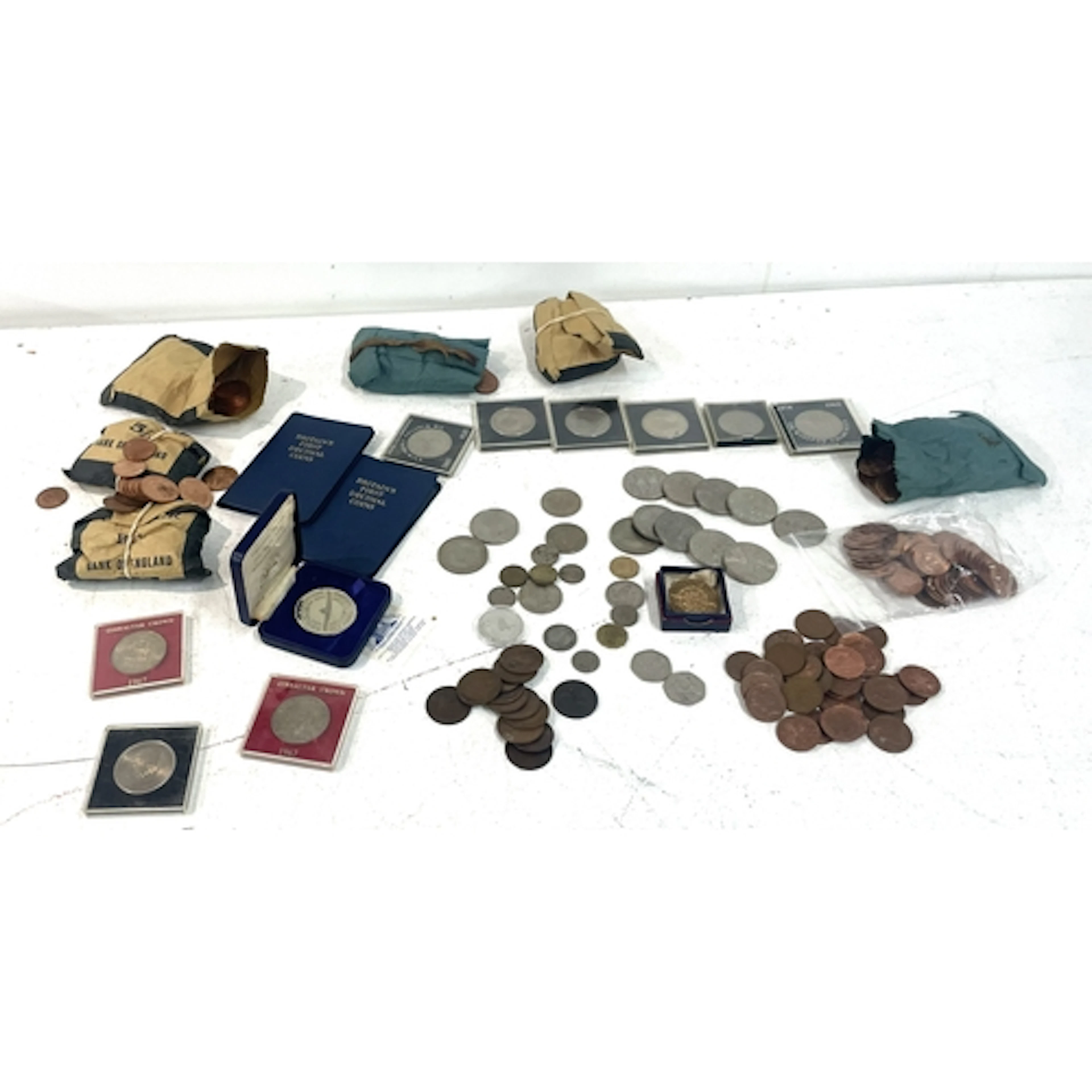 A collection of commemorative crowns, paper money bags conta...