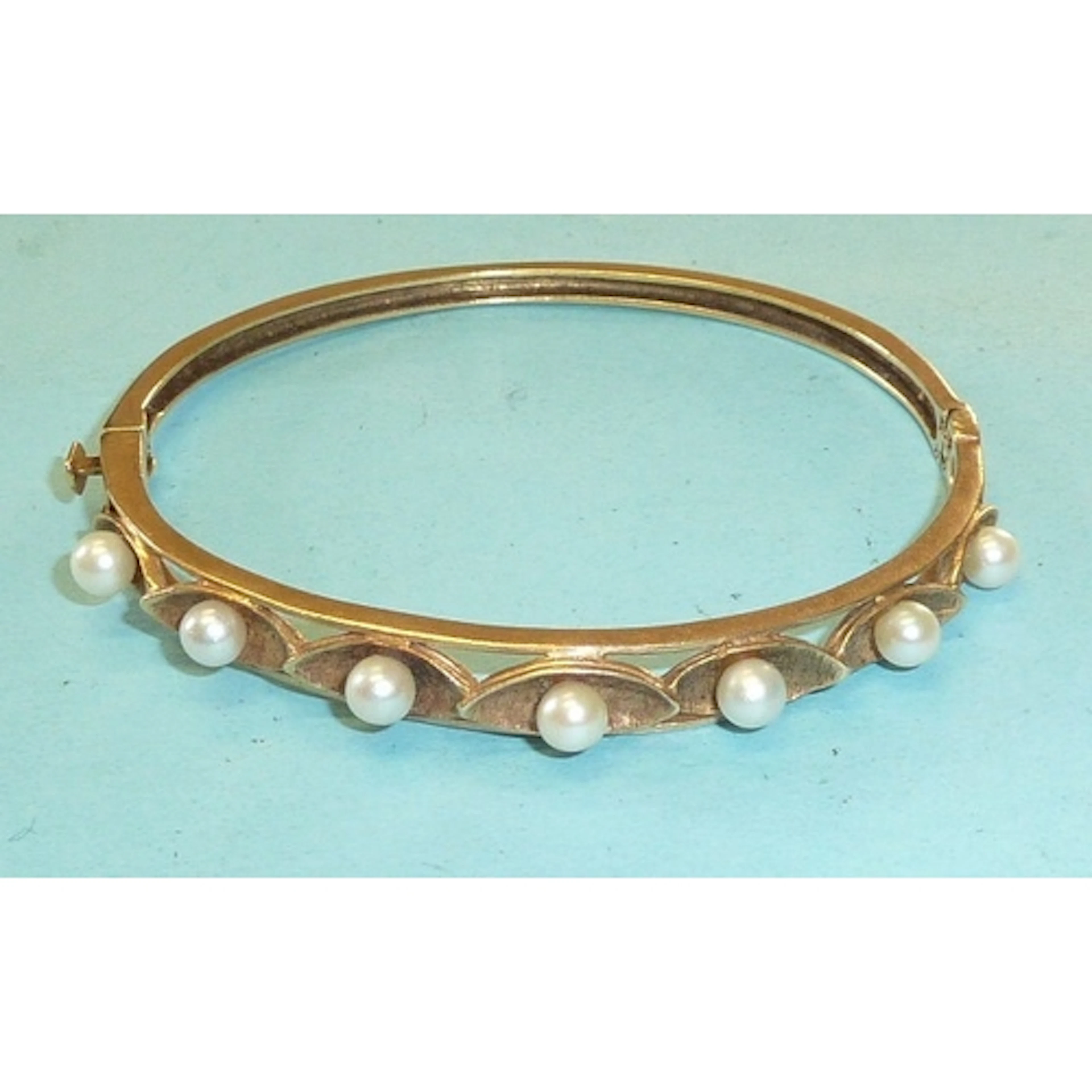 A 14k yellow gold hinged bangle set seven cultured pearls, t...