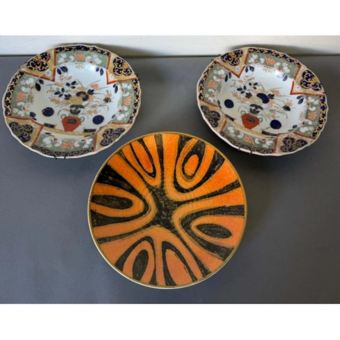 A pair of porcelian charger plates along with a decortive Po...
