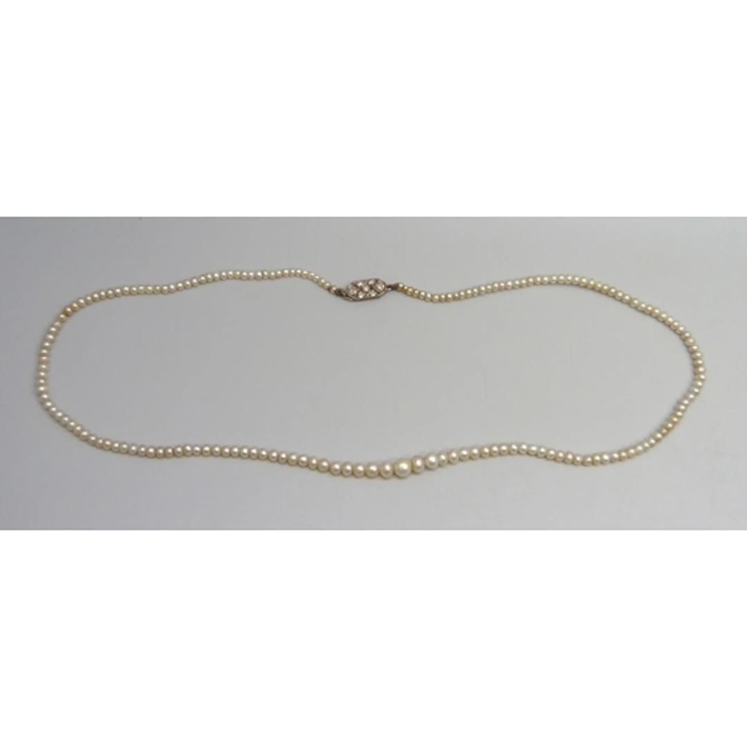 A natural pearl necklace with a white metal old cut diamond ...