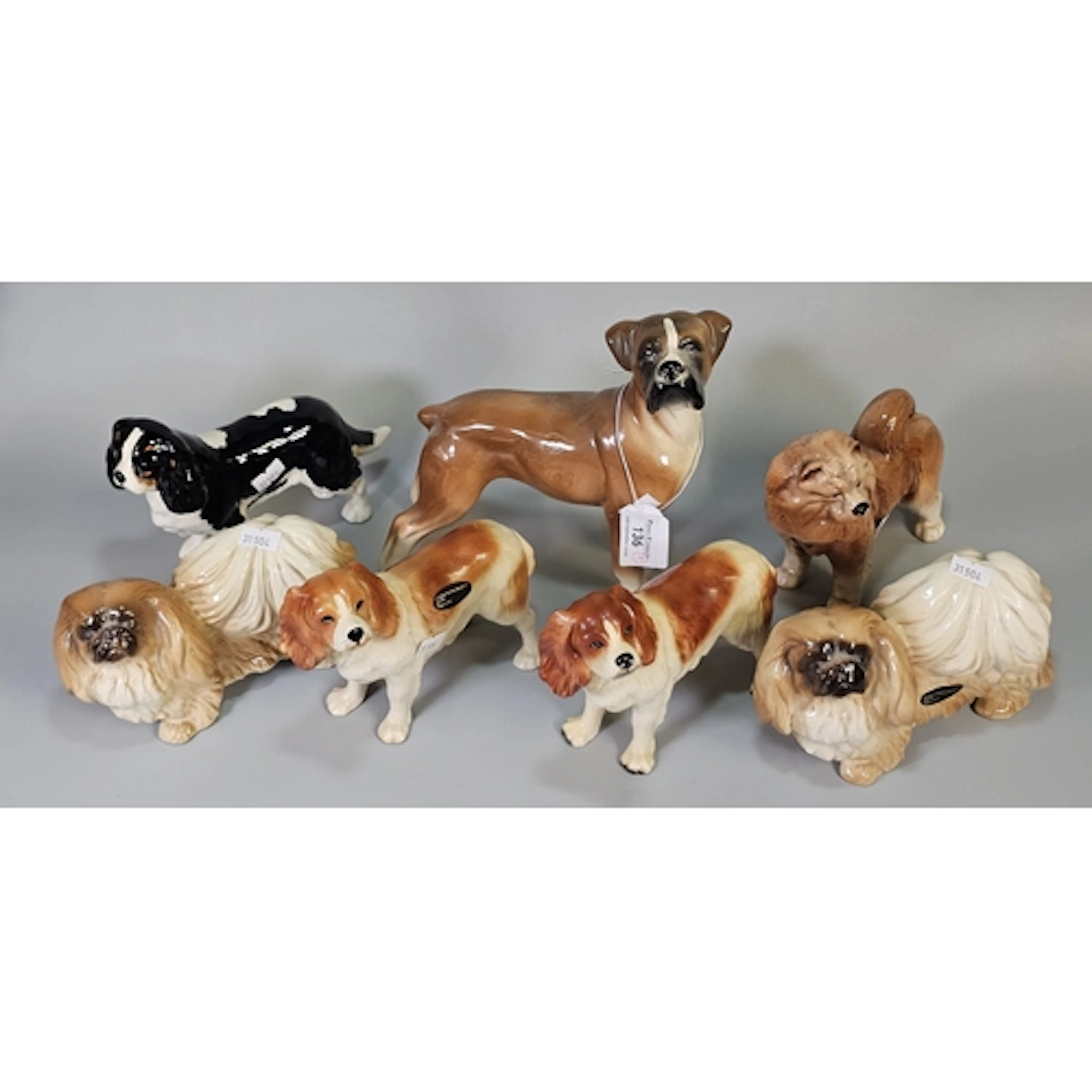 Collection of ceramic dog figurines, including Pekingese, Bo...