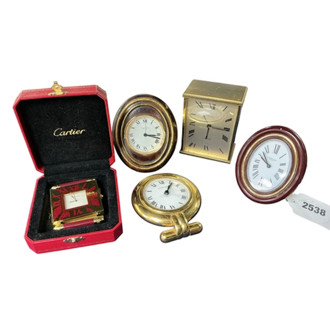 A collection of five Cartier clocks, comprising a Baignoire ...
