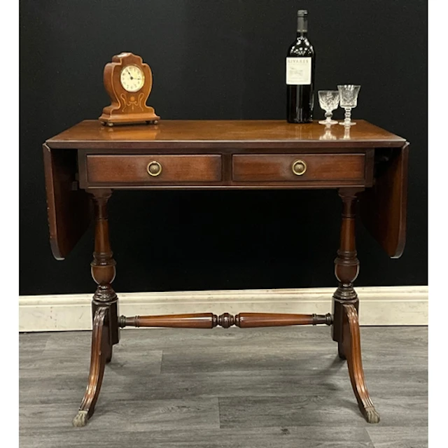 A regency style mahogany sofa table, two round leaves with c...