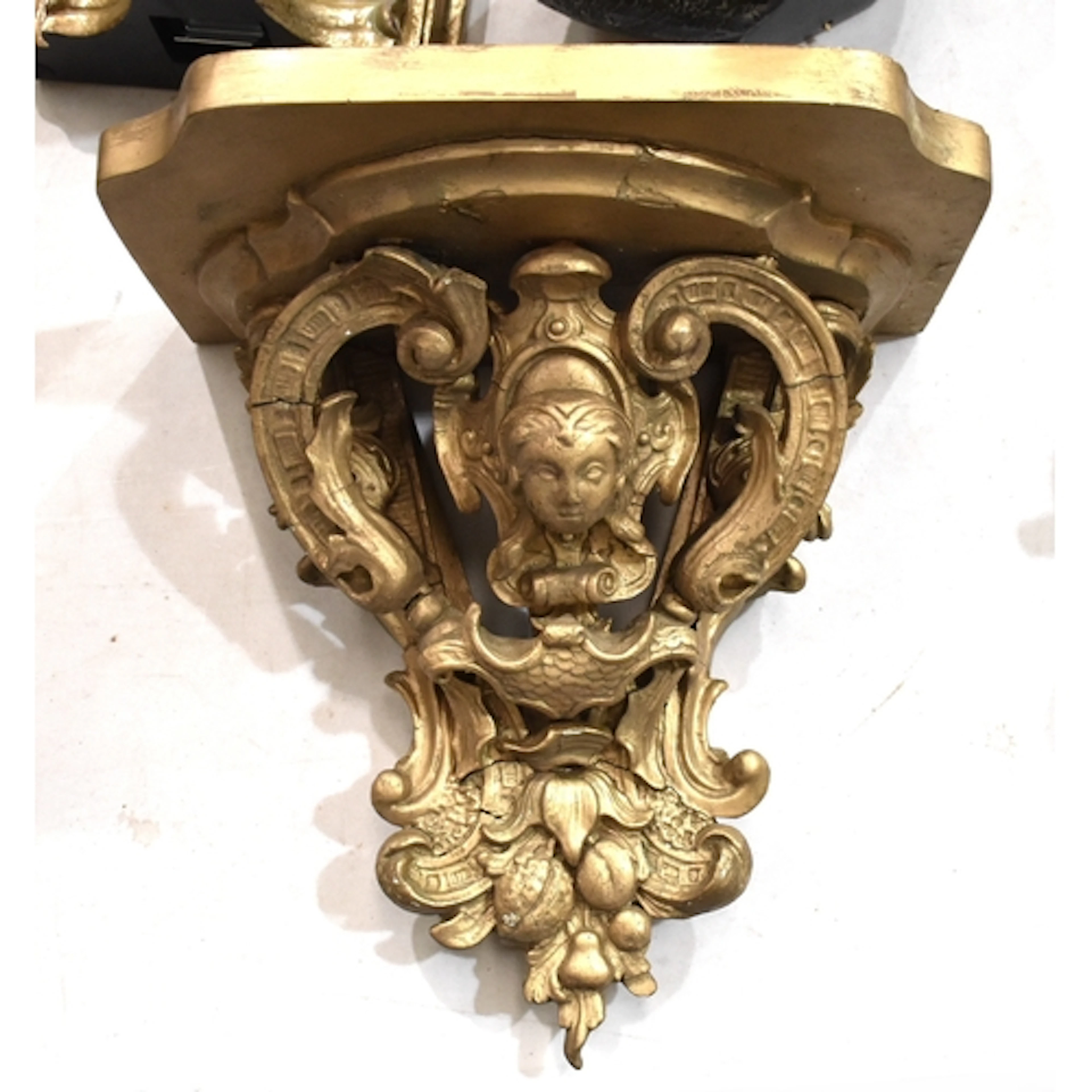 A gilt gesso wall bracket with female mask and scroll decora...