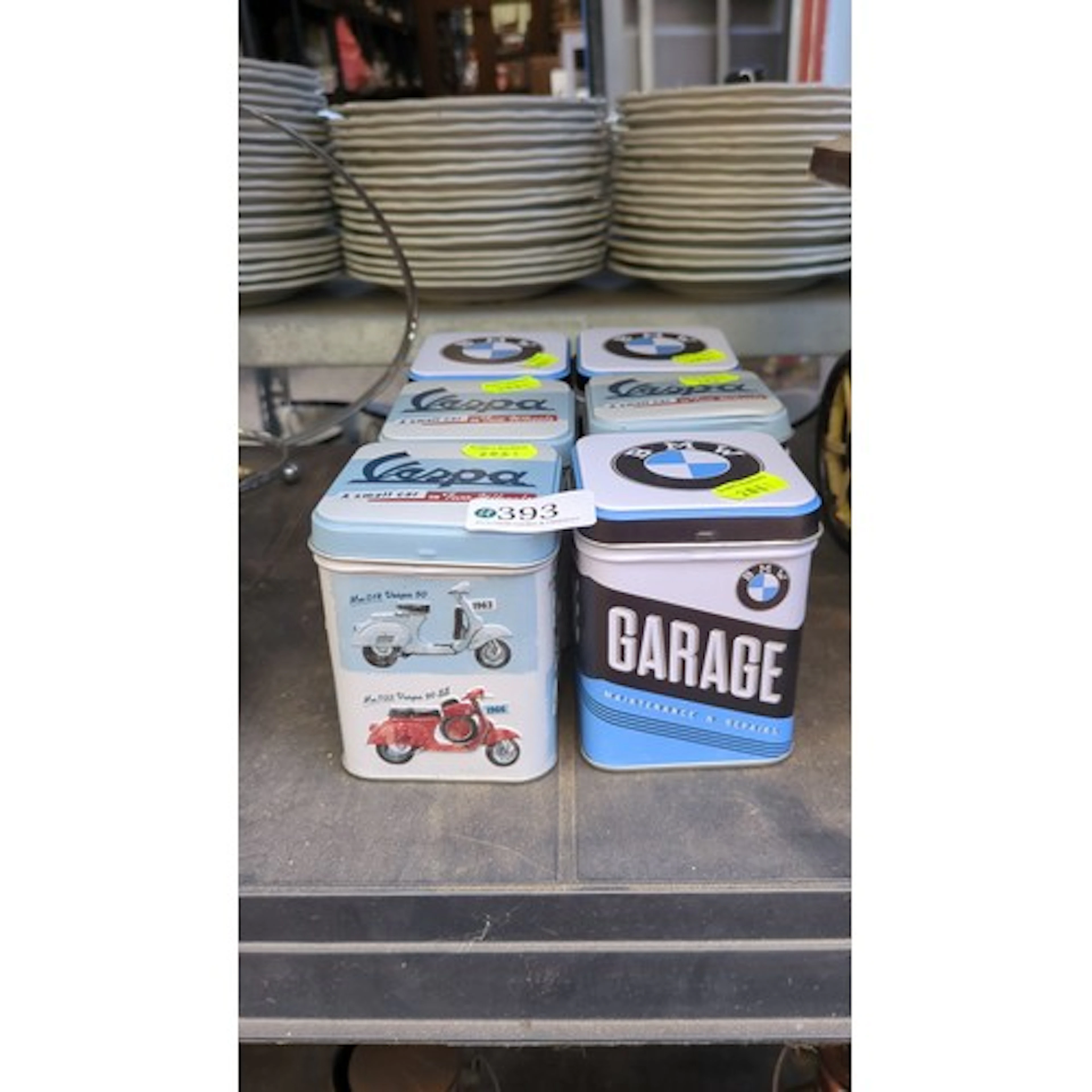 A group of six automotive-themed metal storage tins, includi...