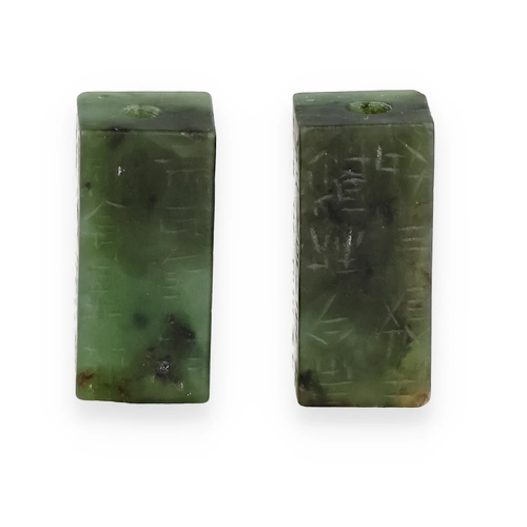 TWO CHINESE SPINACH JADE BEADS Of rectangular form. Inscribe...