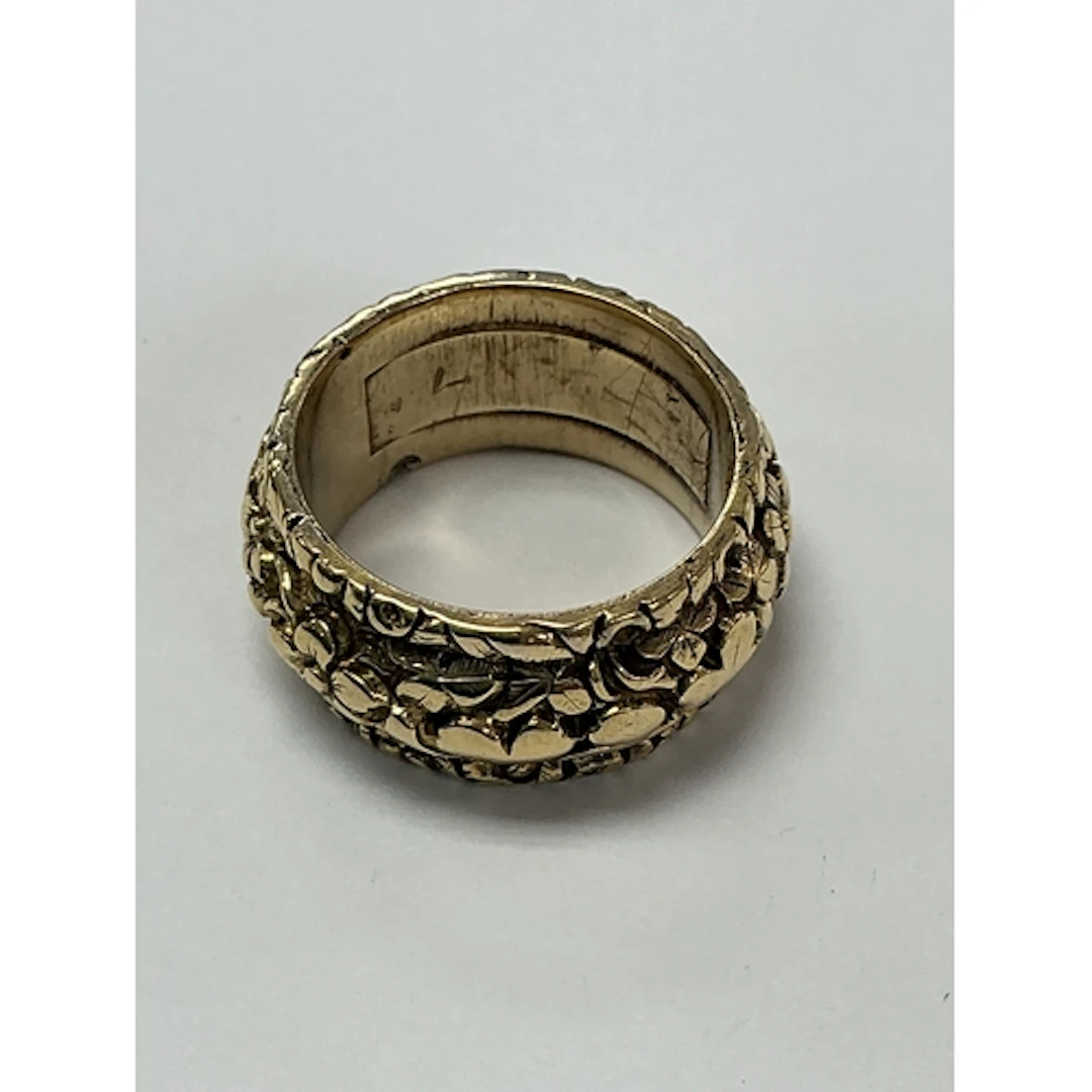 An unmarked yellow gold ring, the thicker band having relief...