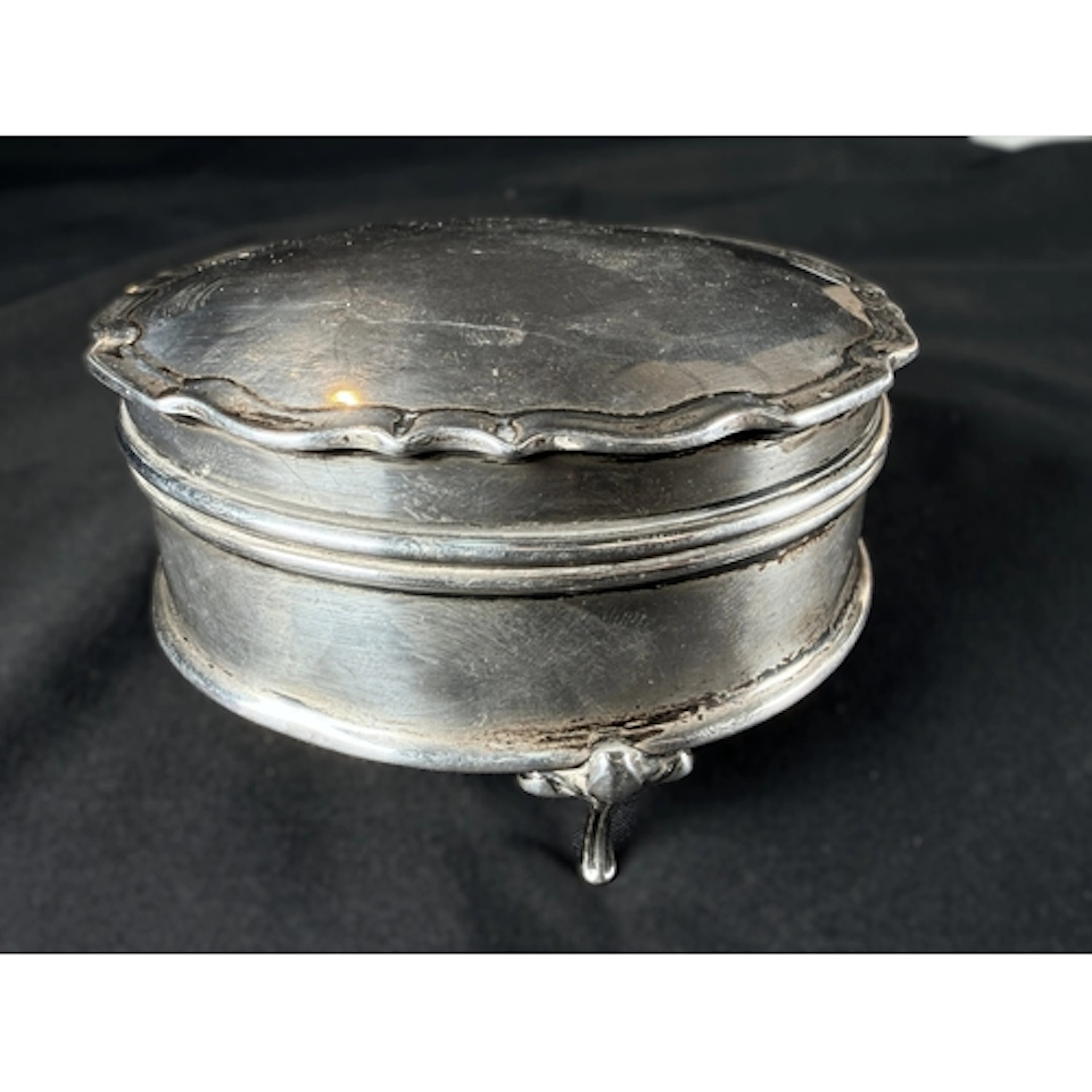 A hall marked silver velvet lined jewellery box on three fee...