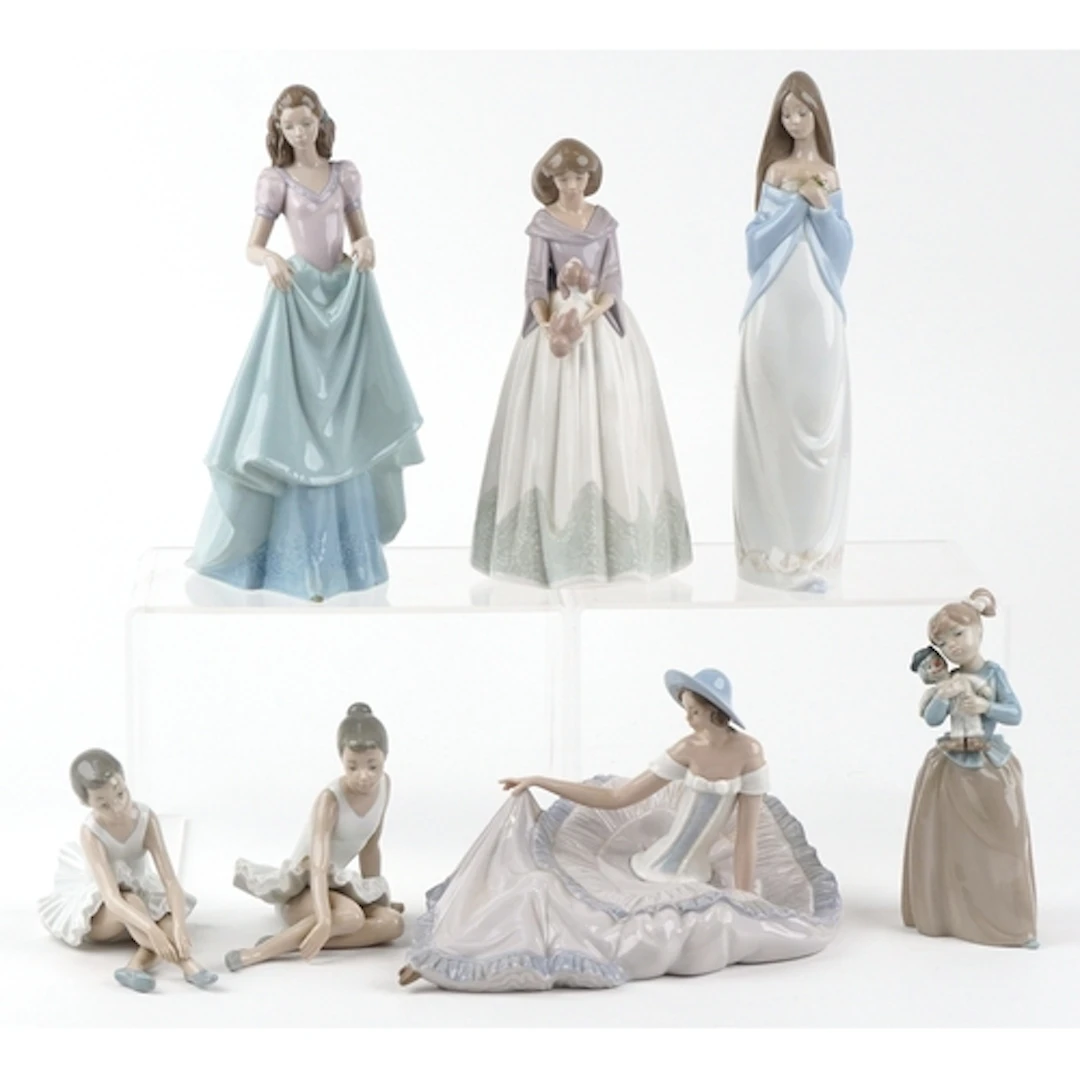 Seven Nao collectable figures including a female holding a p...