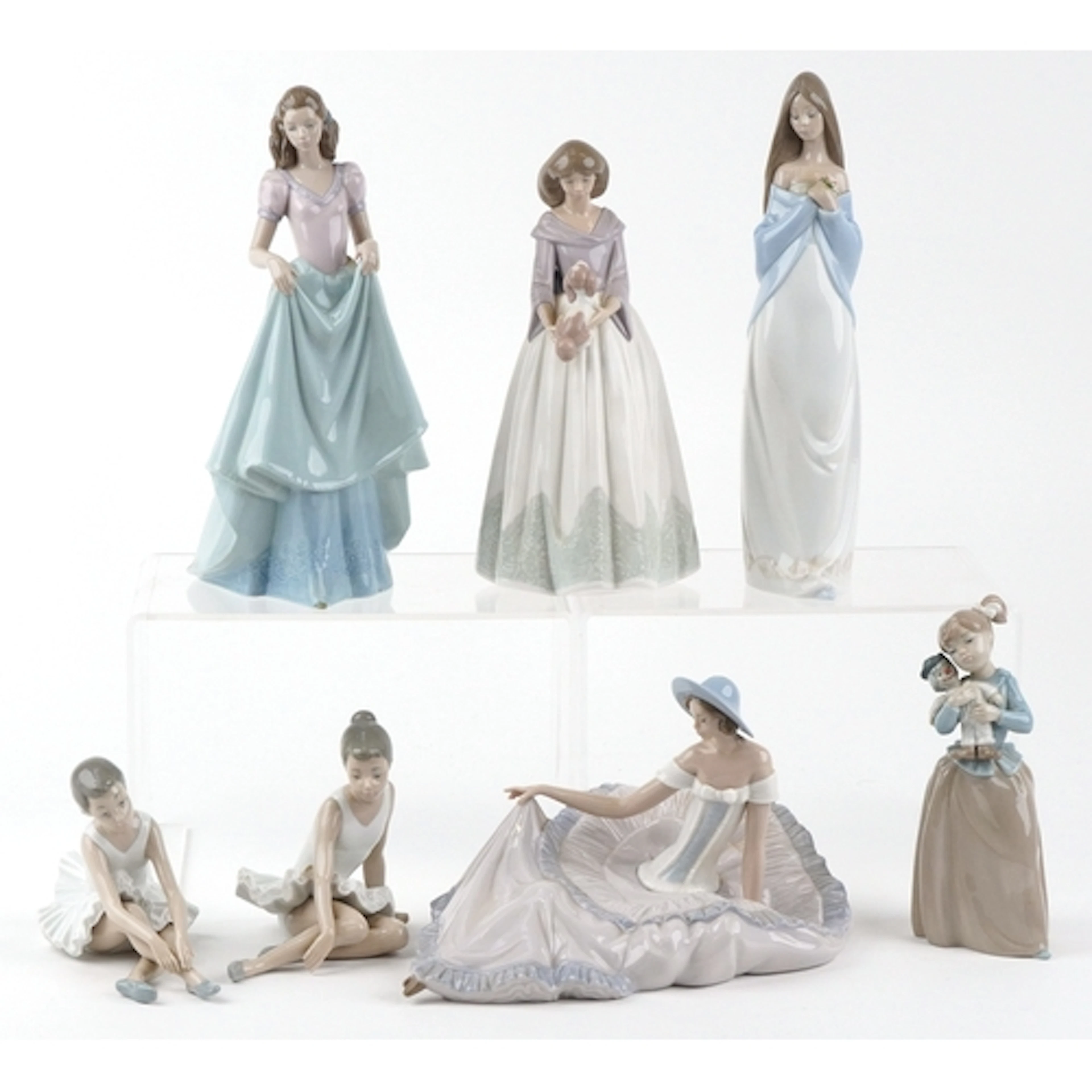 Seven Nao collectable figures including a female holding a p...