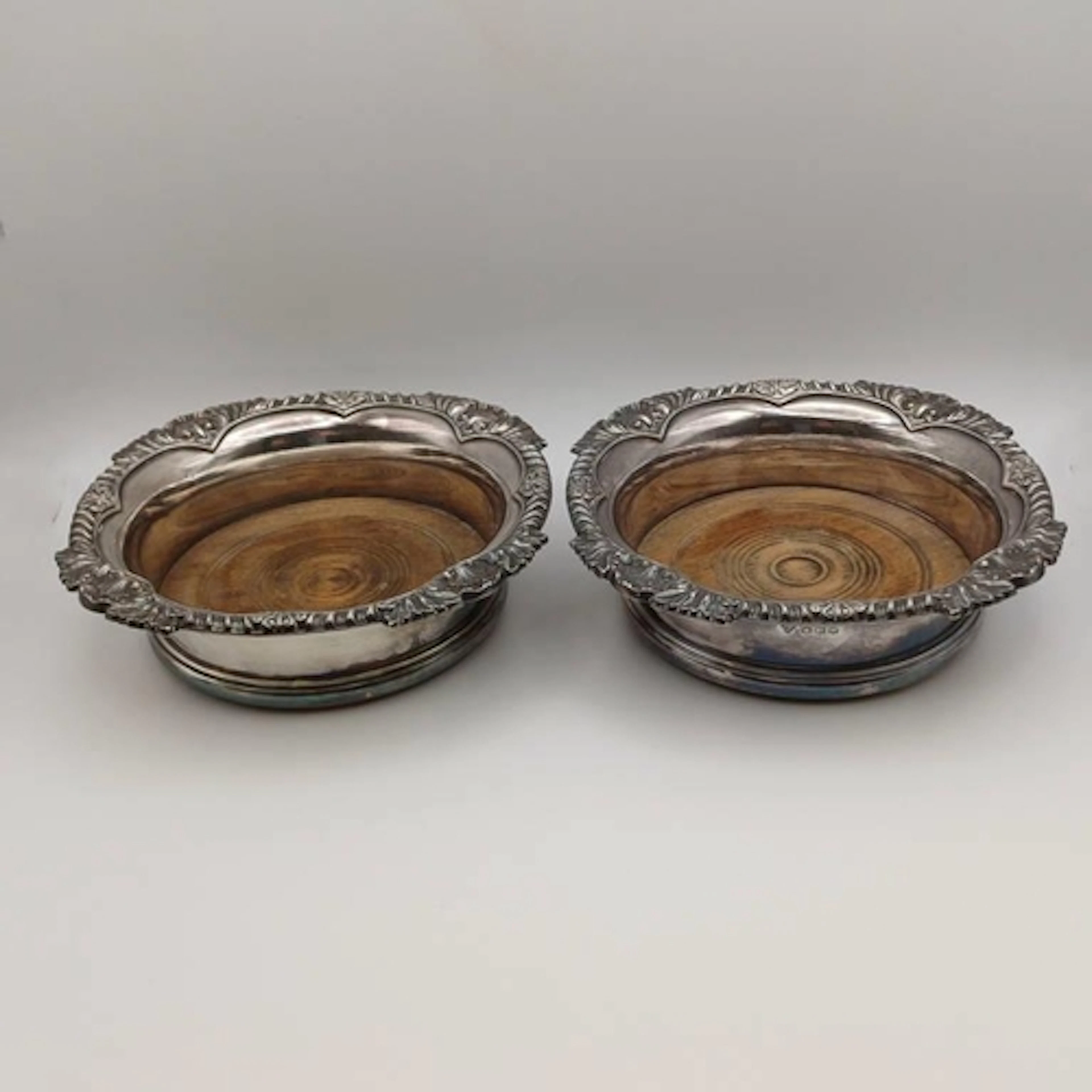 A PAIR OF SILVER WINE SLIDES WITH SCROLL RIMS BY HARRODS LTD...