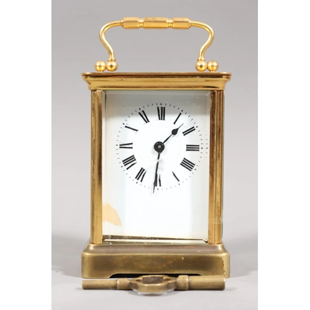 Brass carriage clock mounted with swing-handle, white enamel...