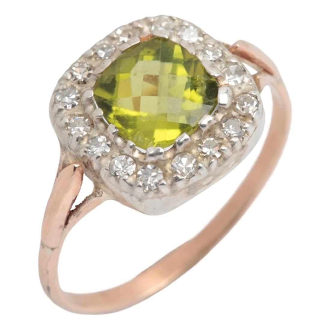 A peridot and diamond ring, claw-set with a mixed-cut perido...