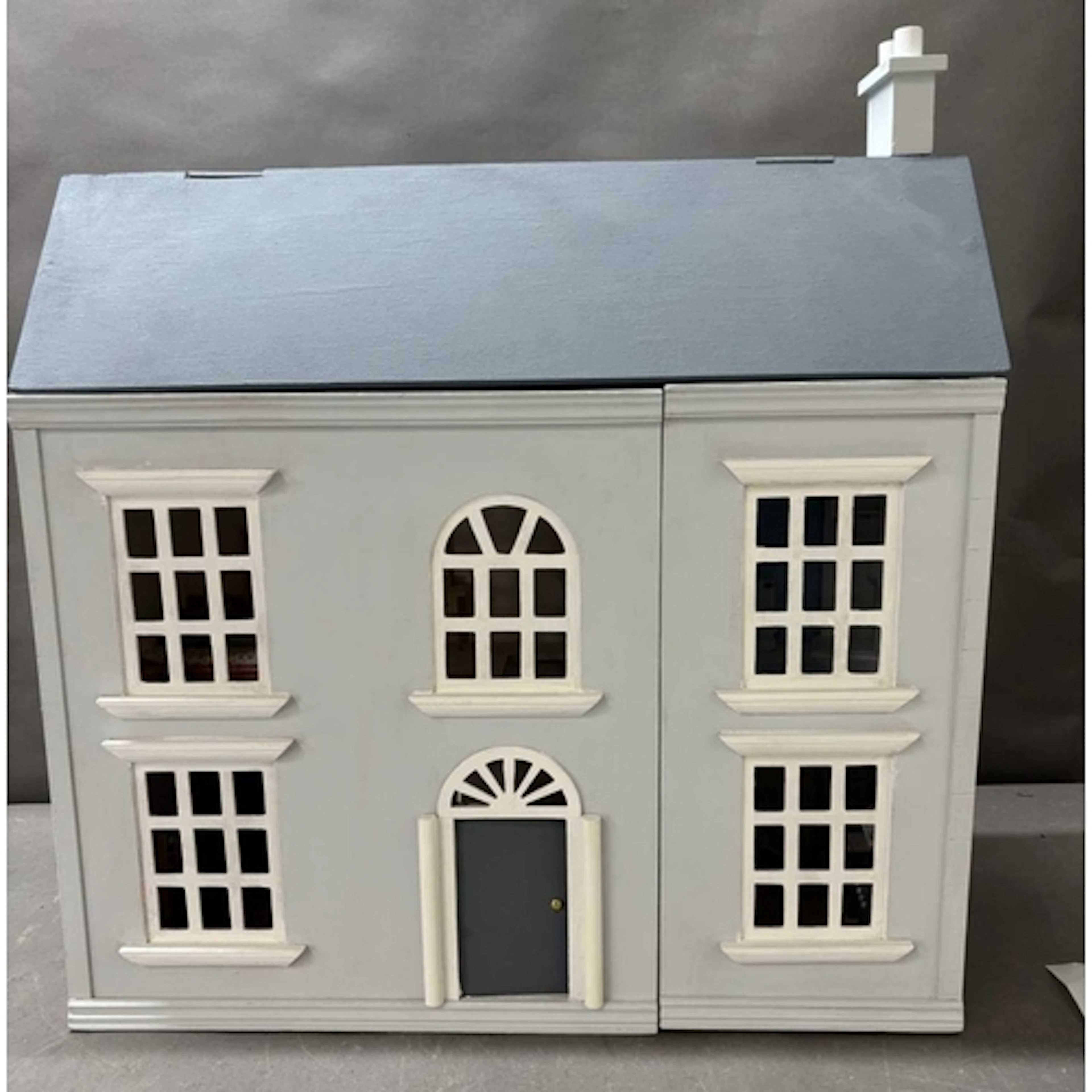 A scatch built dolls house with some furniture and figures ...
