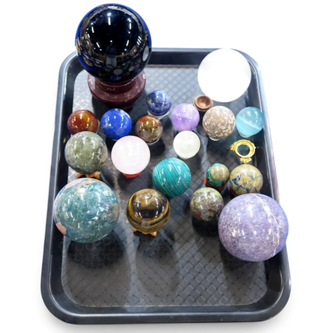 A group of specimen balls including amethyst, malecite, tige...