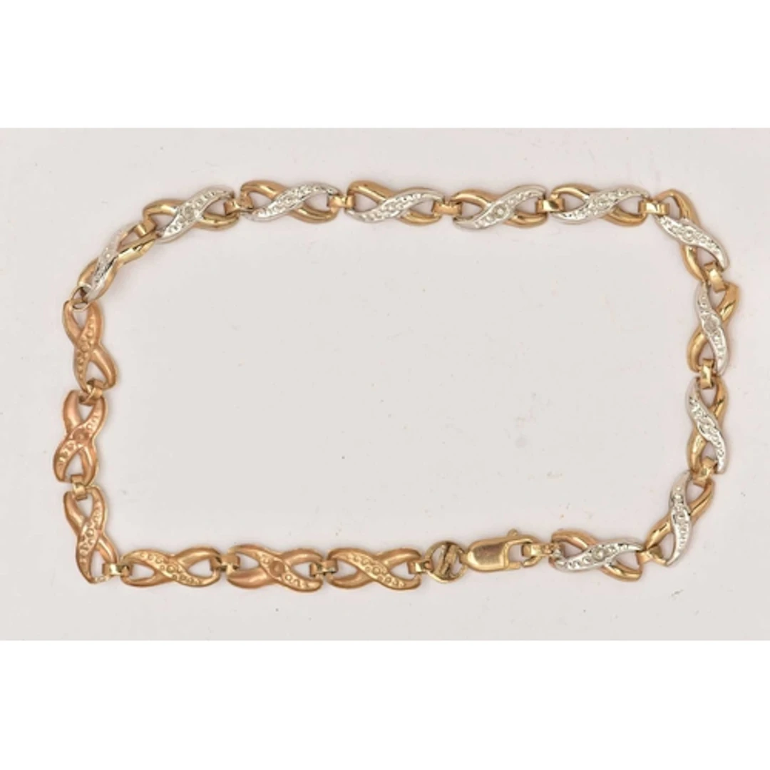 A 9CT GOLD BI-COLOUR DIAMOND SET BRACELET, designed as a ser...