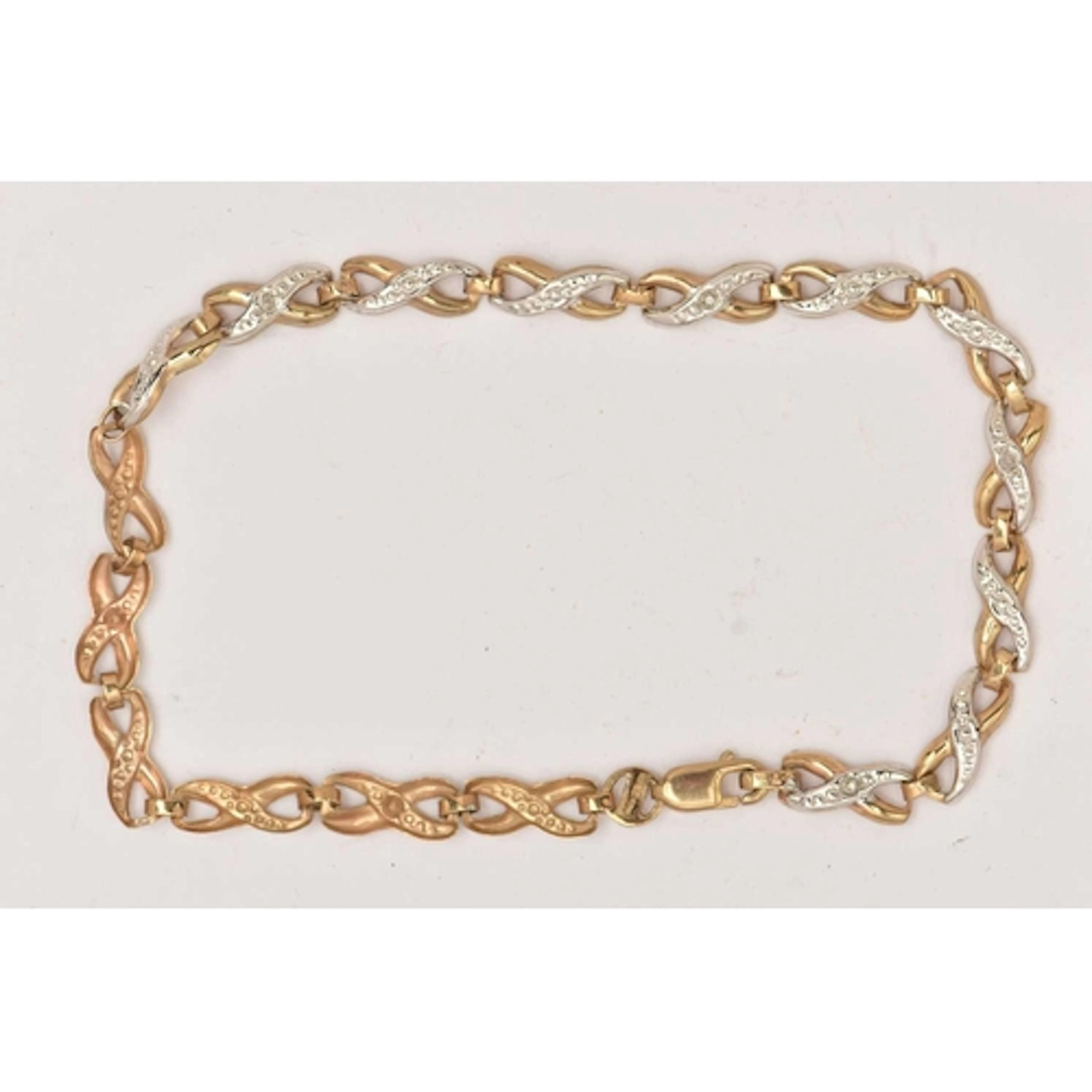 A 9CT GOLD BI-COLOUR DIAMOND SET BRACELET, designed as a ser...