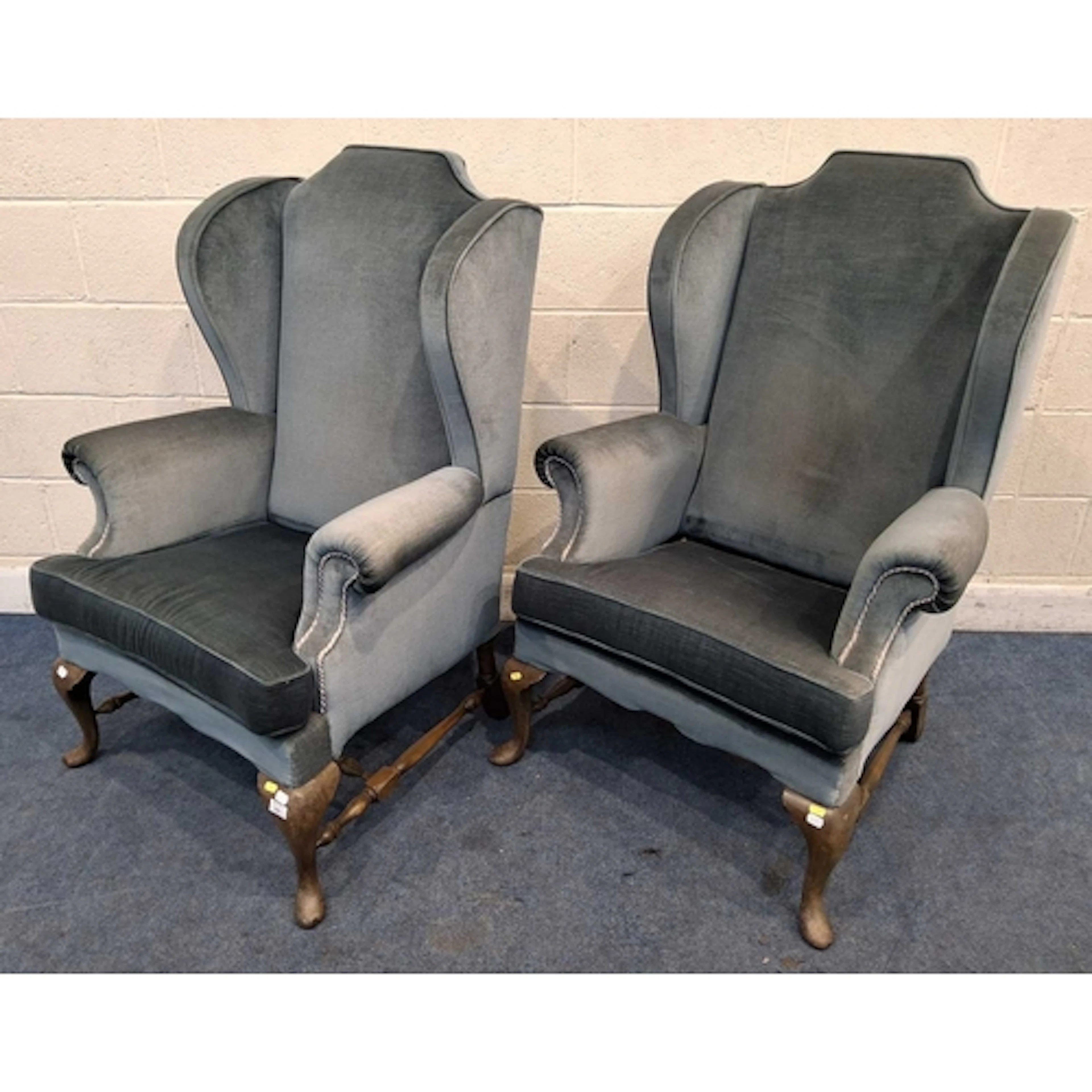 A PAIR OF GEORGIAN STYLE WING BACK ARMCHAIRS, with light blu...