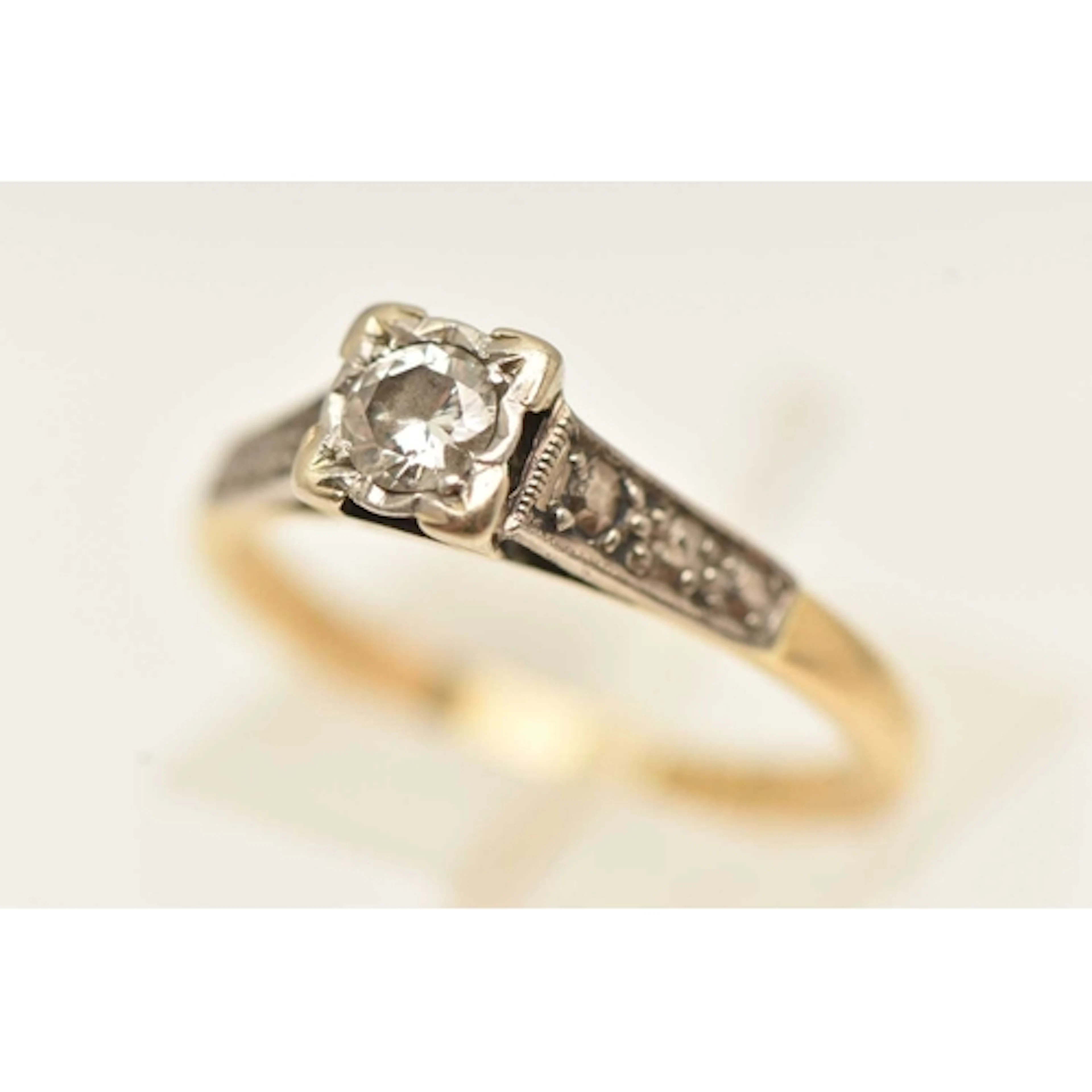 A YELLOW METAL SINGLE STONE DIAMOND RING, set with a round b...
