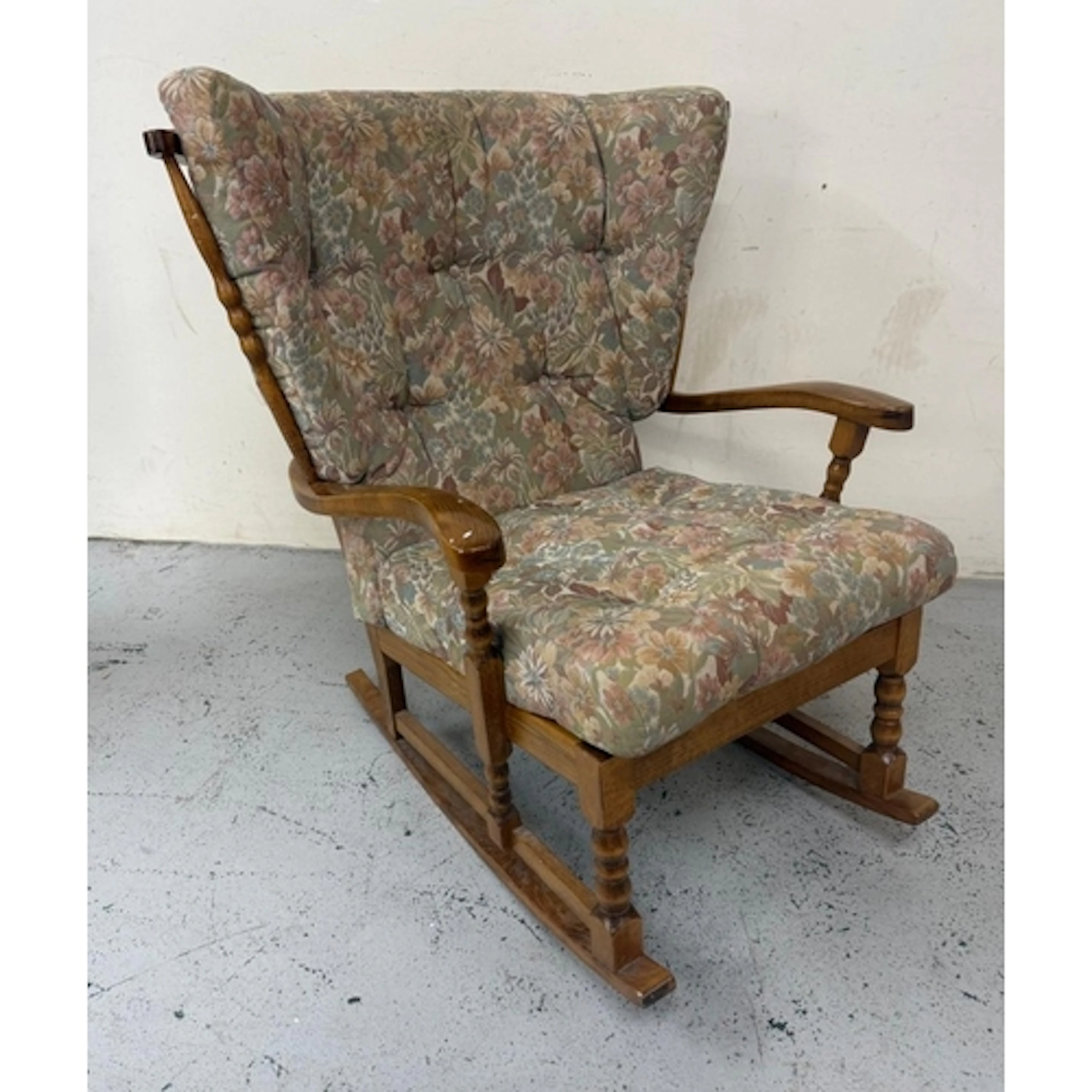 A mid-century stick back rocking chair in a floral upholster...