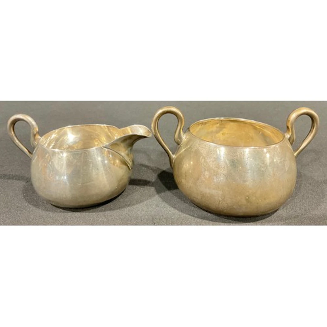 A Victorian sugar bowl and cream jug, stylised loop handles,...