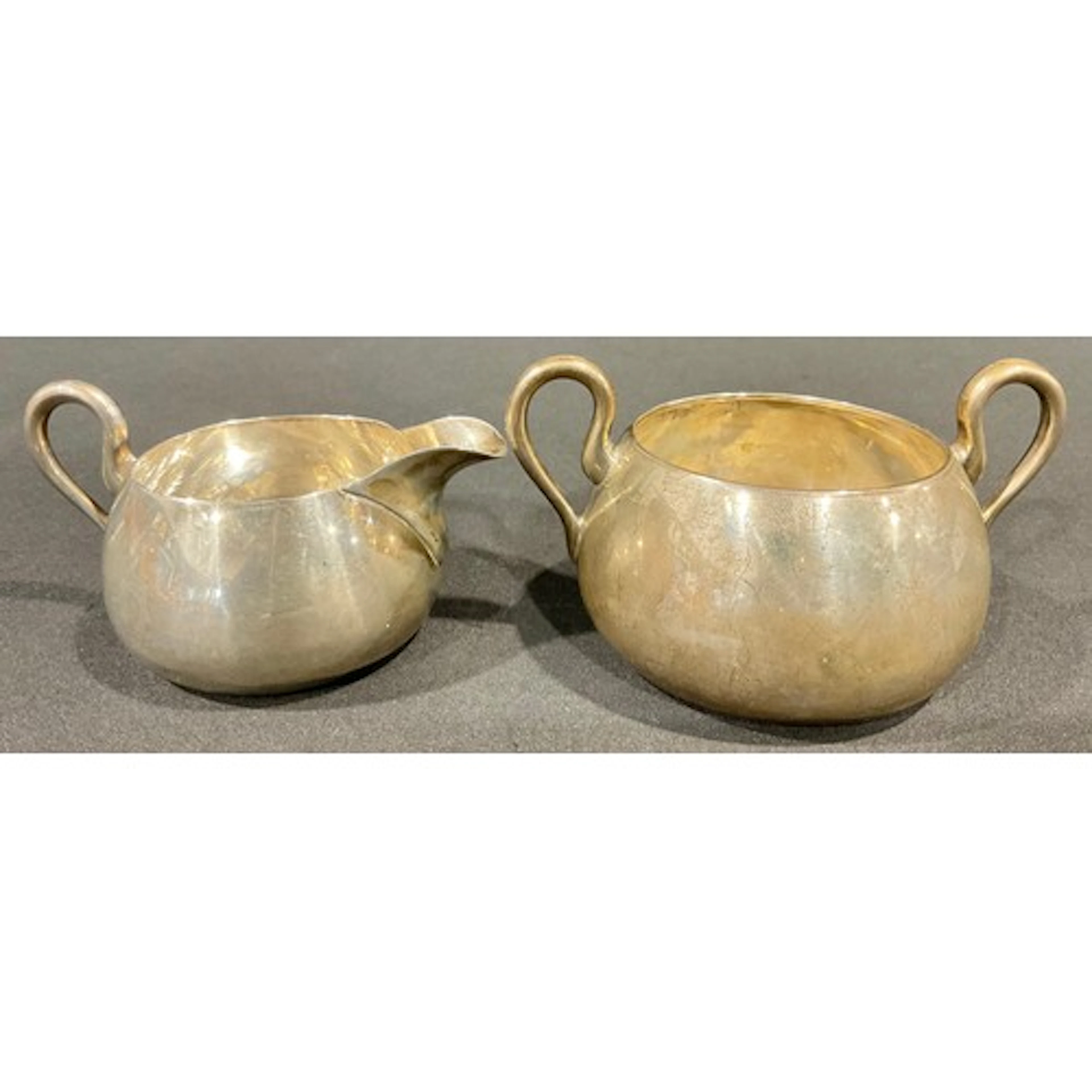 A Victorian sugar bowl and cream jug, stylised loop handles,...