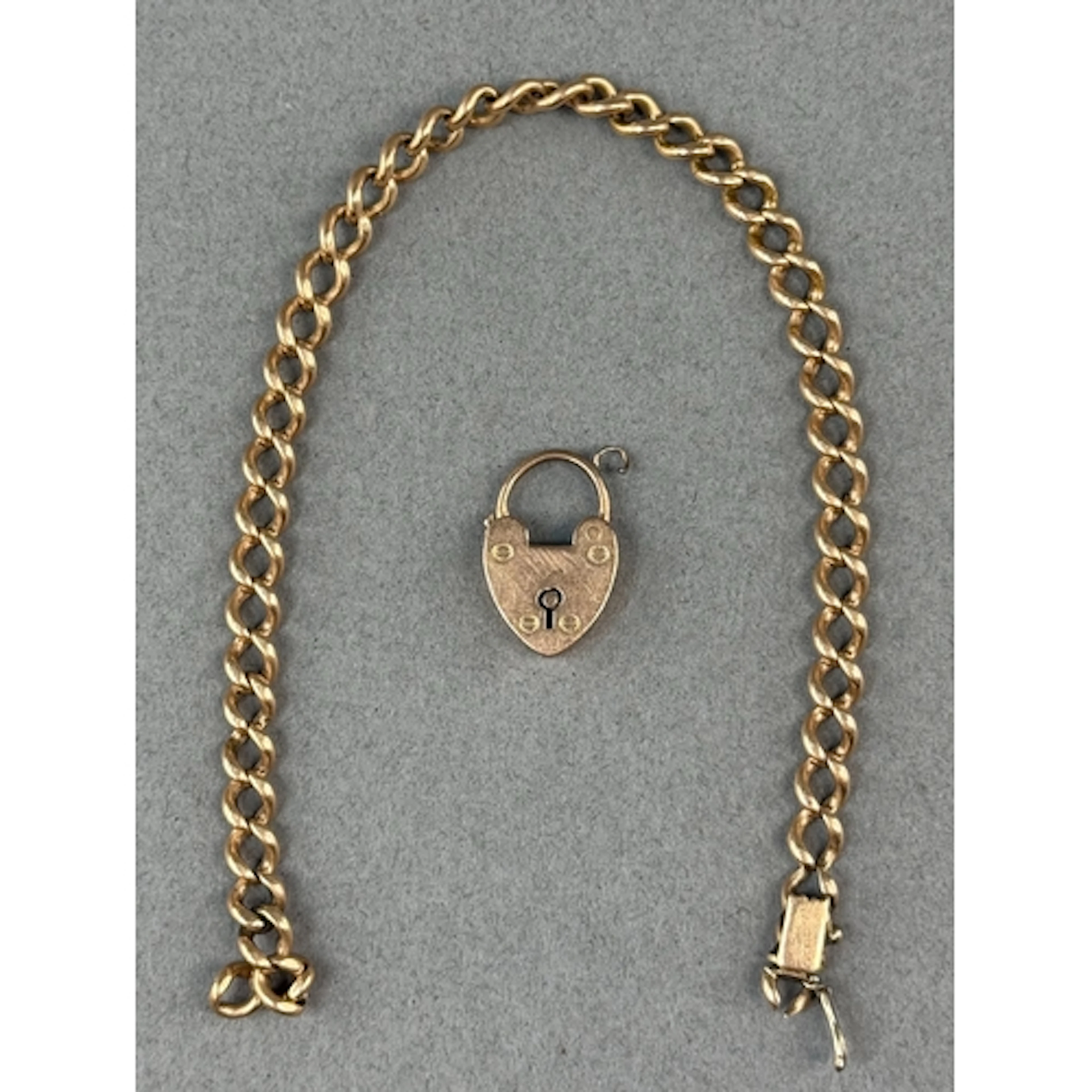 Jewellery: a yellow metal curb link bracelet, broken, testin...