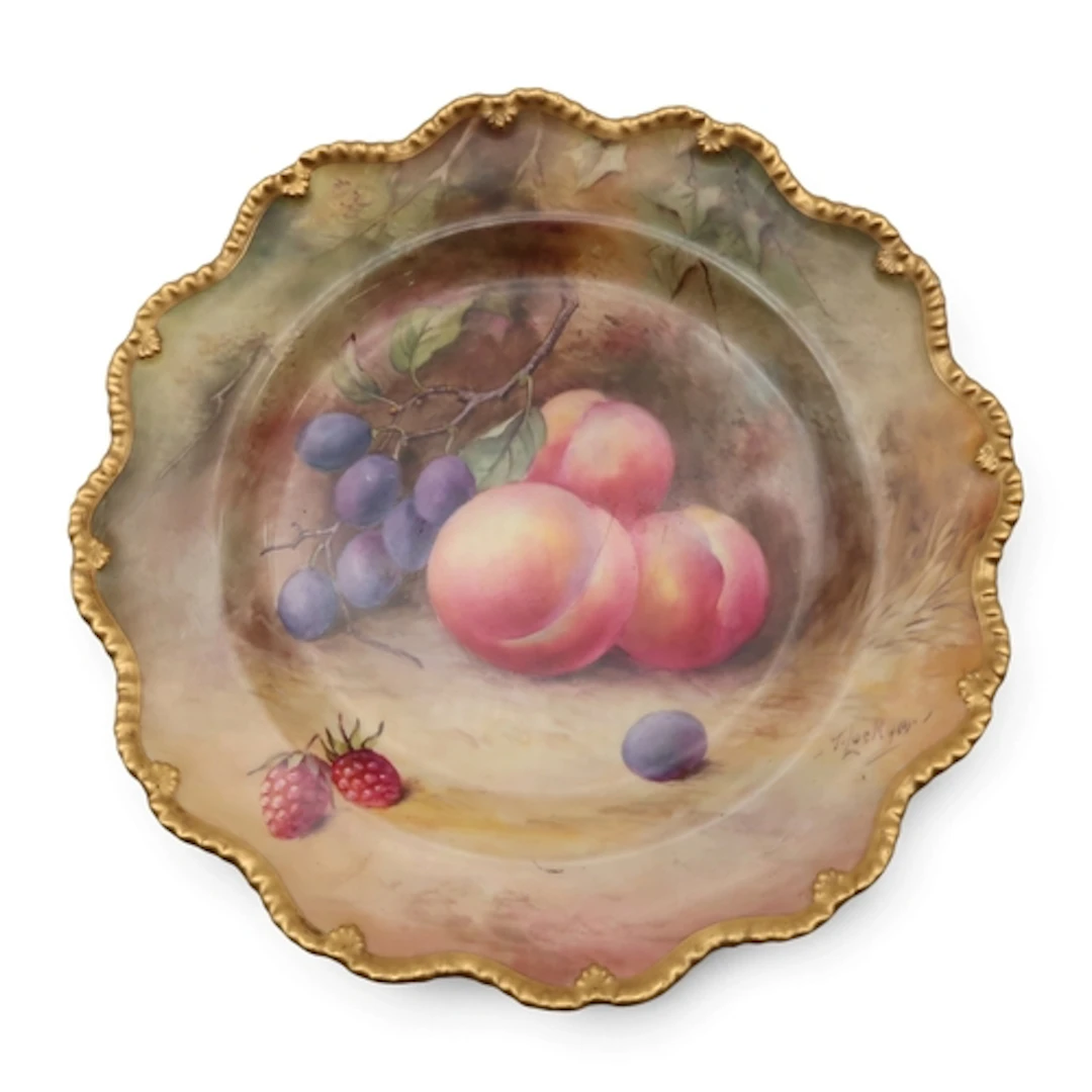 A Royal Worcester plate painted with peaches and damsons and...
