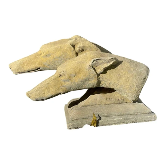 A composition stone sculpture of two greyhound heads. Raised...