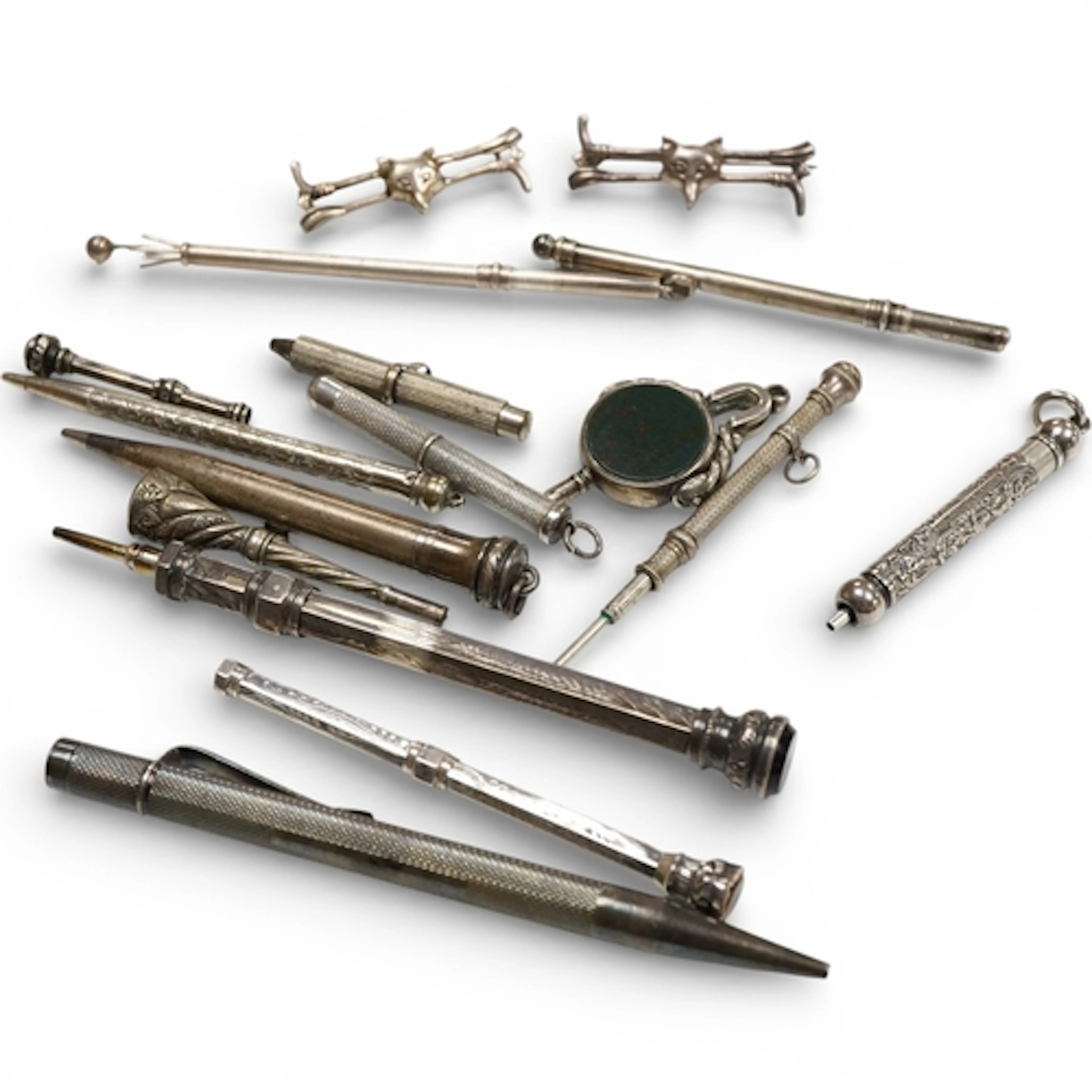 An engine turned silver pencil, two swizzle sticks, one silv...
