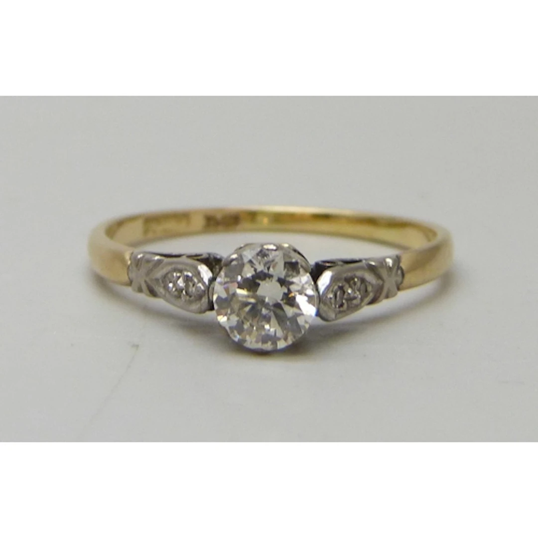 An 18ct gold and platinum diamond solitaire ring with diamon...