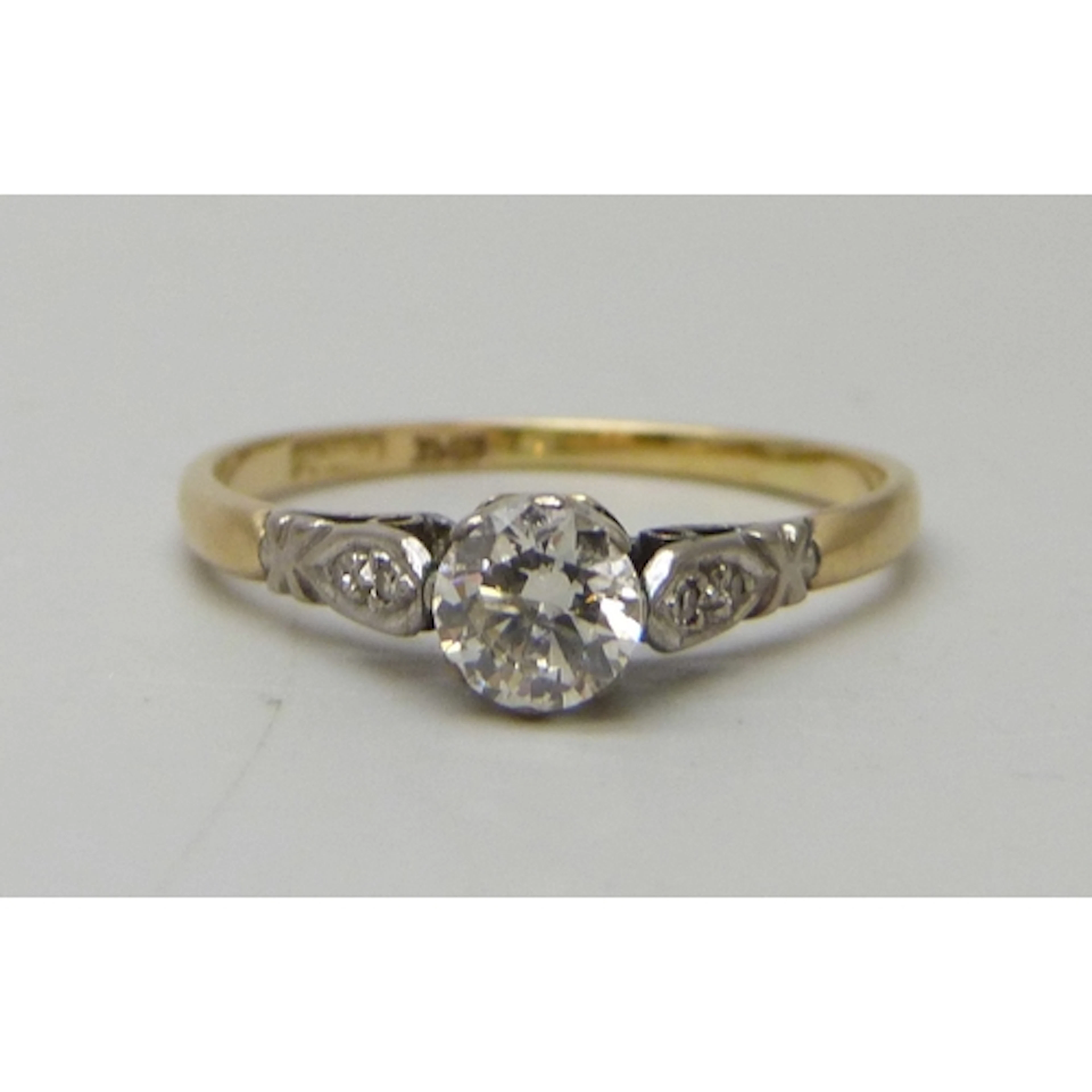 An 18ct gold and platinum diamond solitaire ring with diamon...