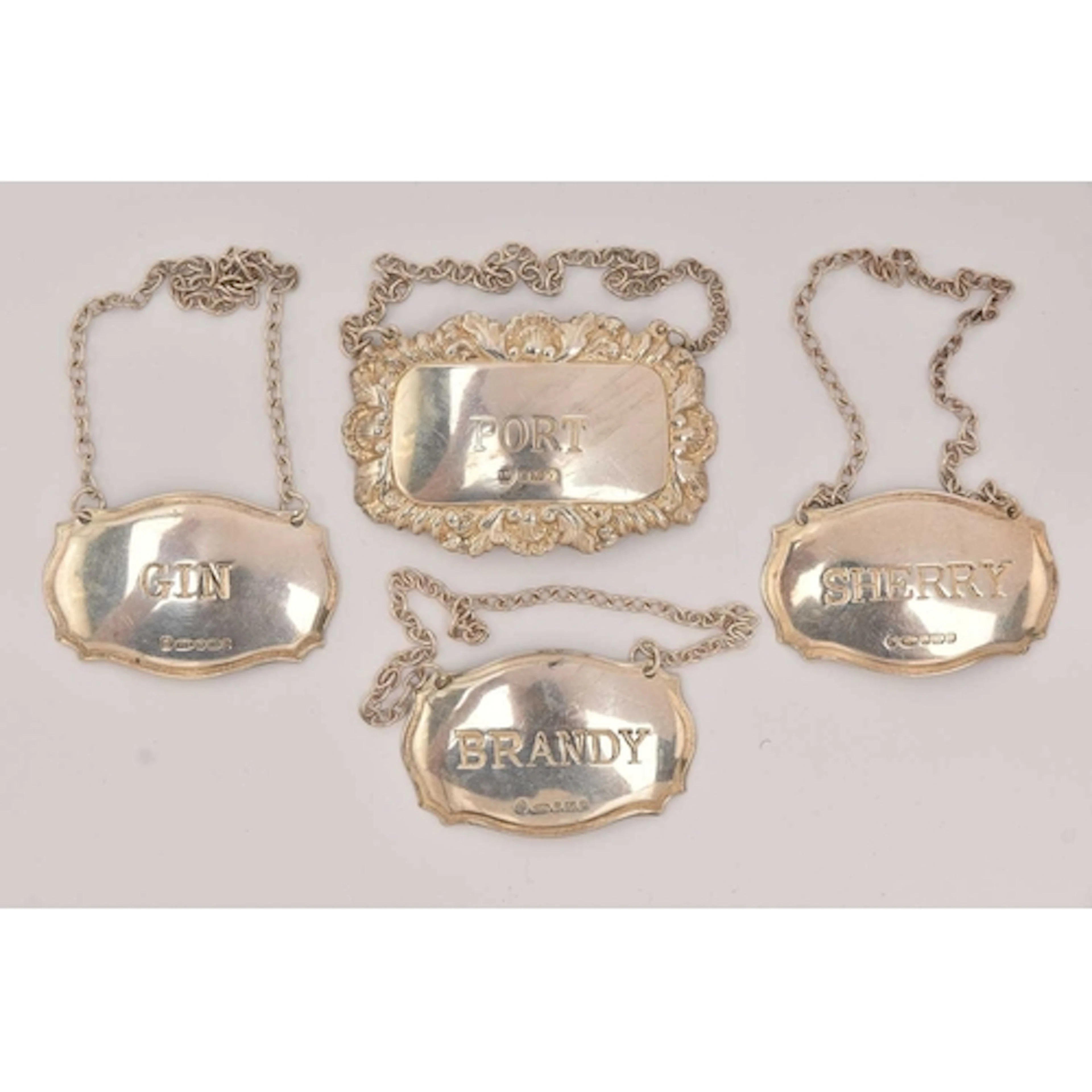 FOUR SILVER DECANTER LABELS, one for 'Gin, Brandy, Sherry' m...