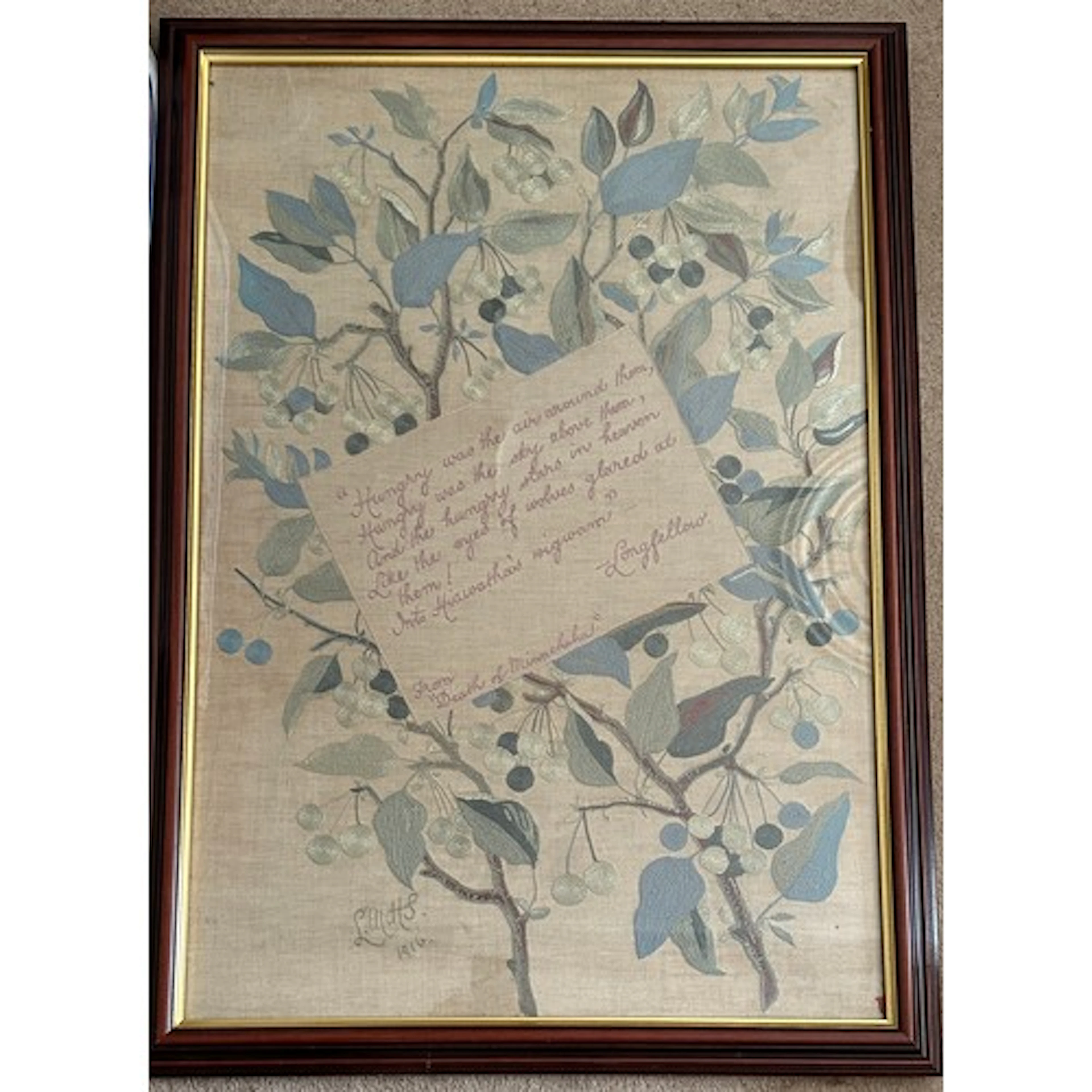 A large framed embroidered panel with an excerpt from Longfe...