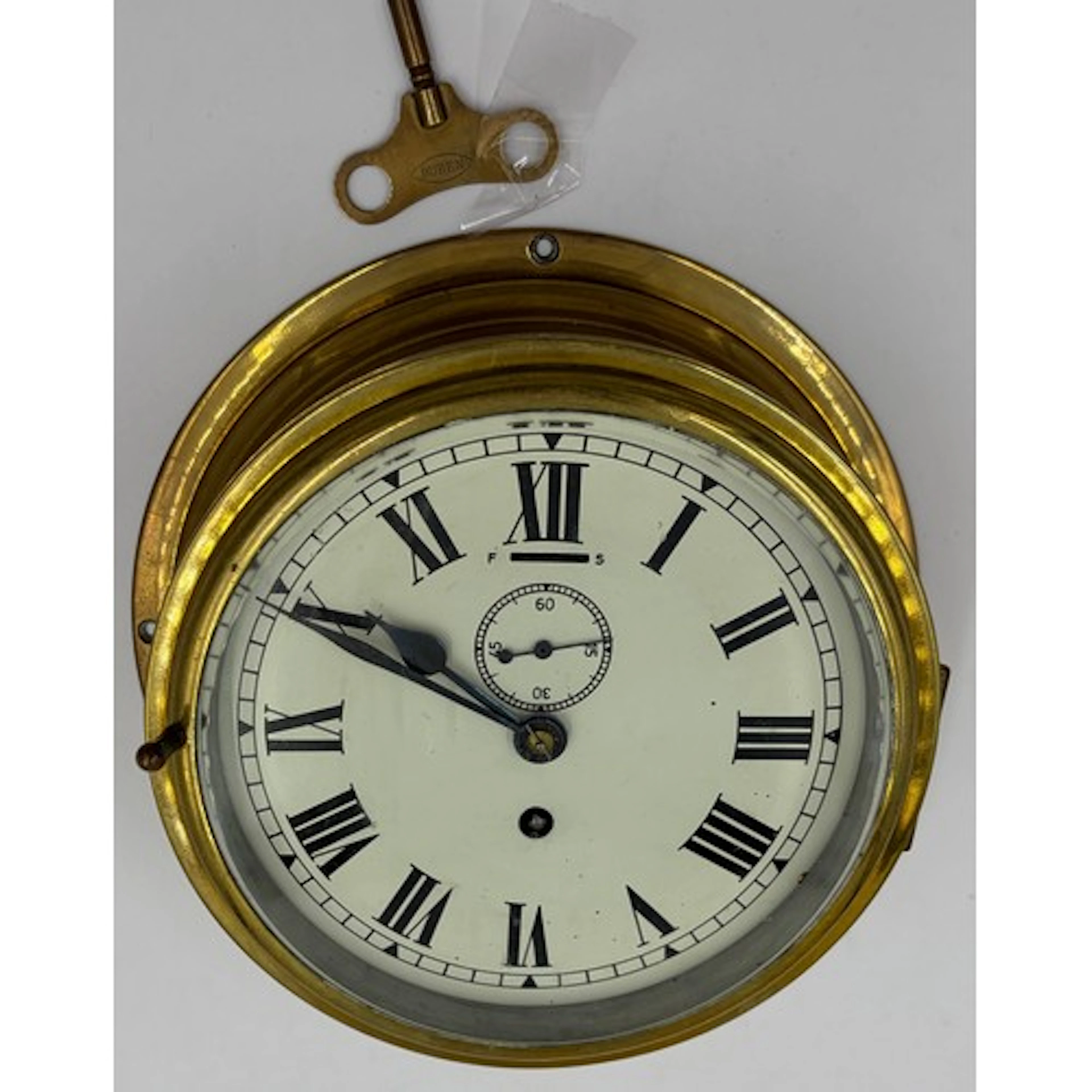 Brass ship's clock with cream dial and roman numerals, with ...