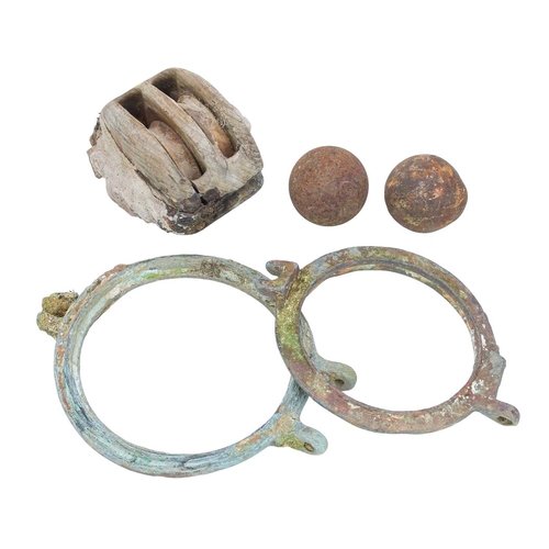 Shipwreck items. Two cannon balls, a porthole, and a pulley.