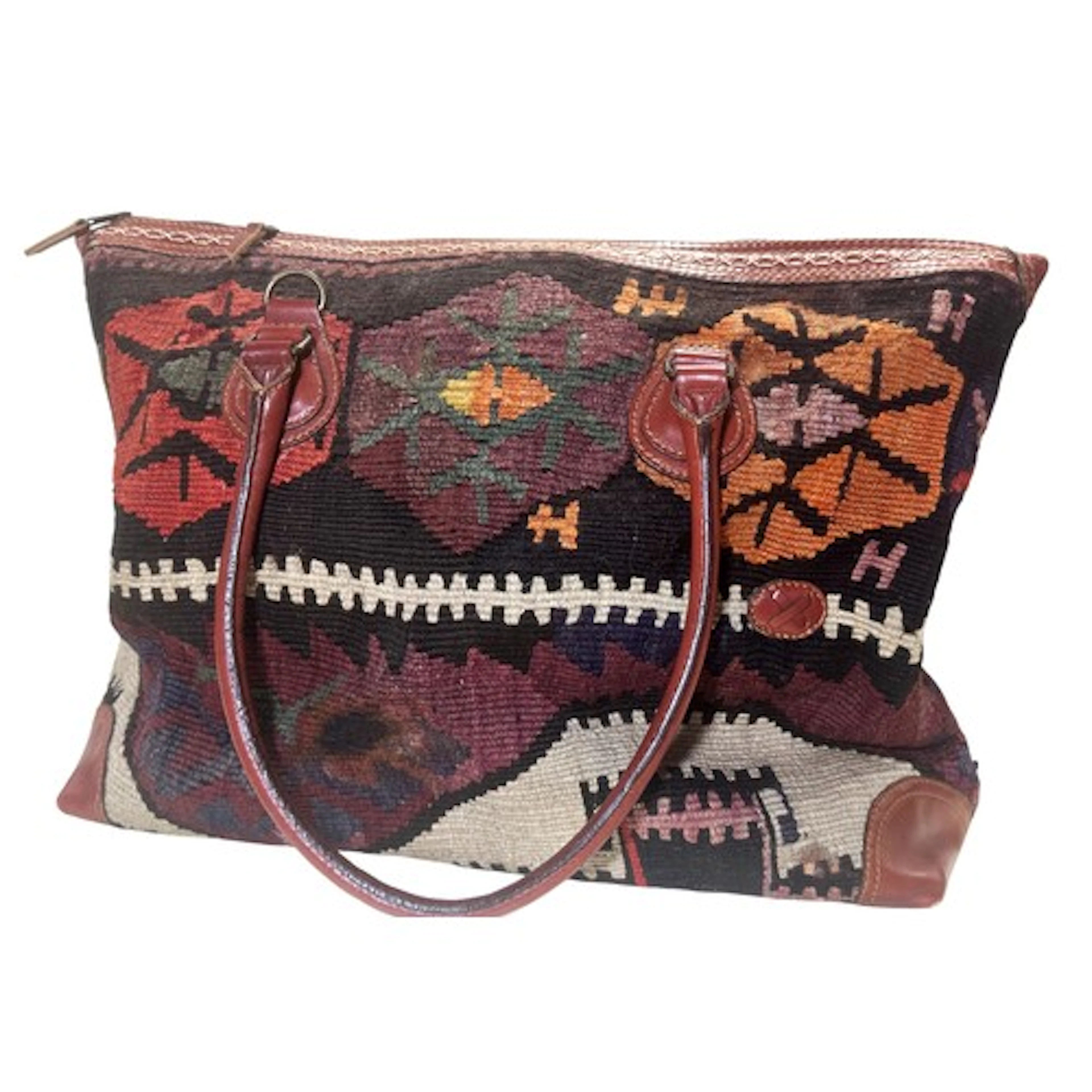 A vintage Turkish kilim carpet bag with stitched leather han...