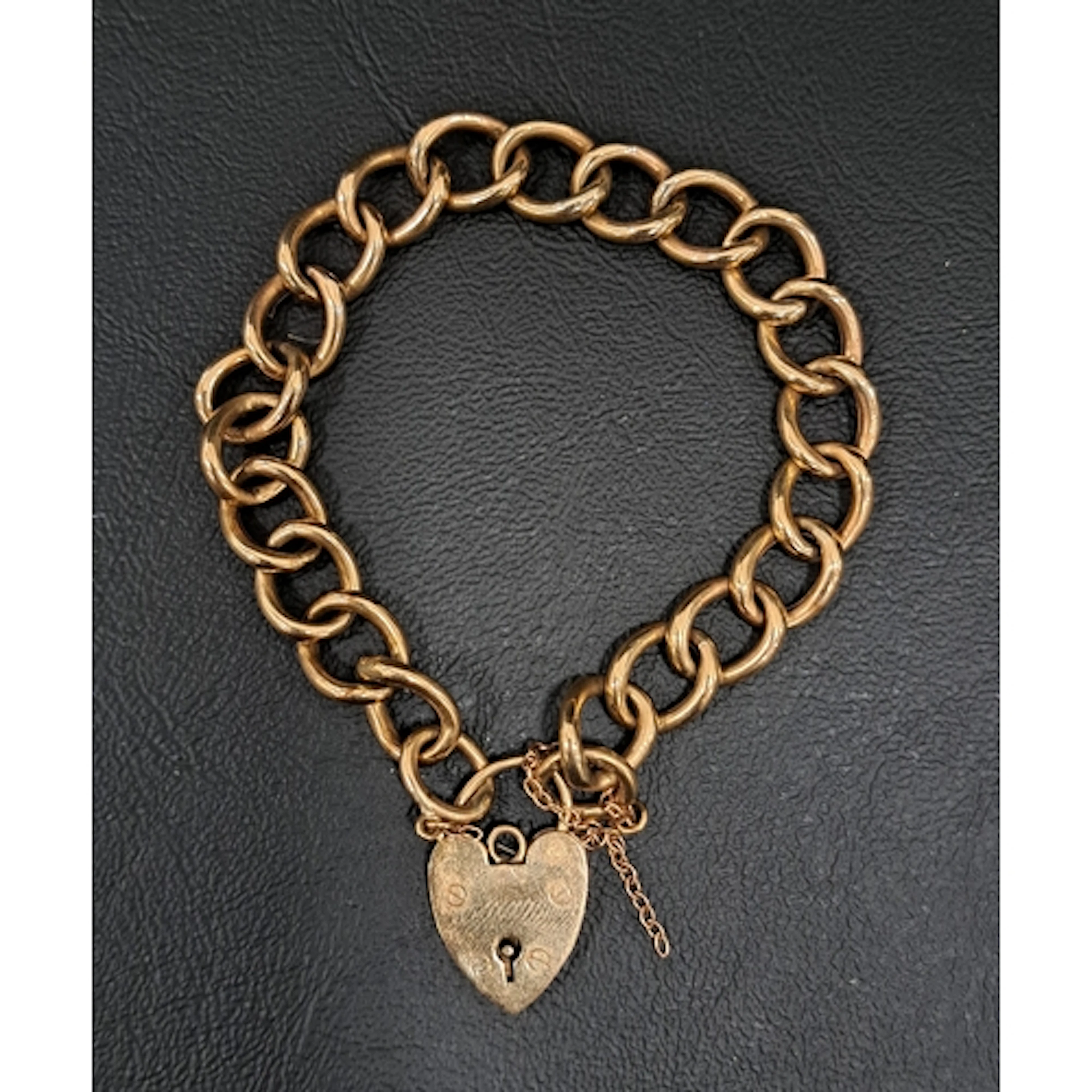 NINE CARAT GOLD CURB LINK BRACELET with nine carat gold hear...