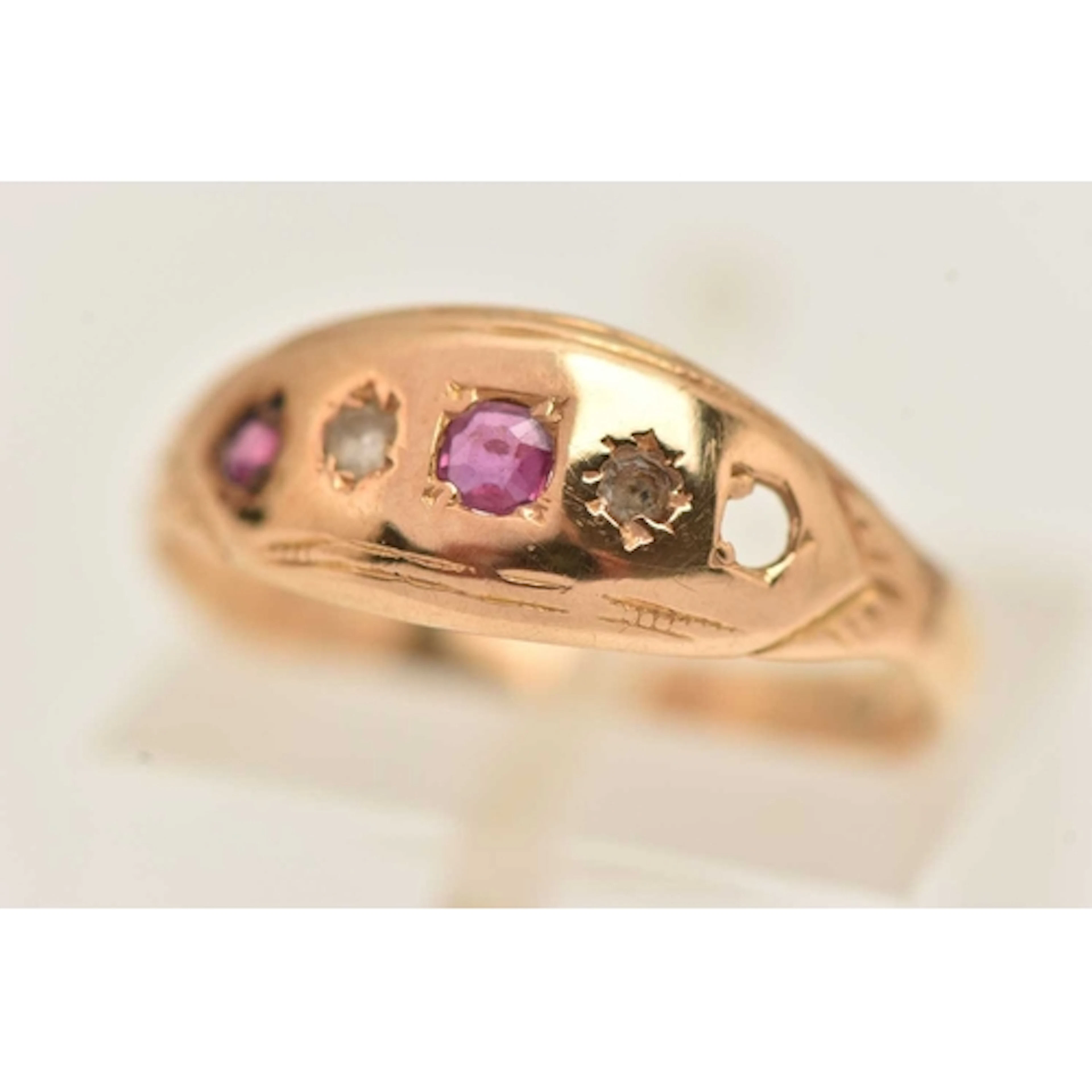 A YELLOW METAL GEM SET RING, set with colourless and red spi...