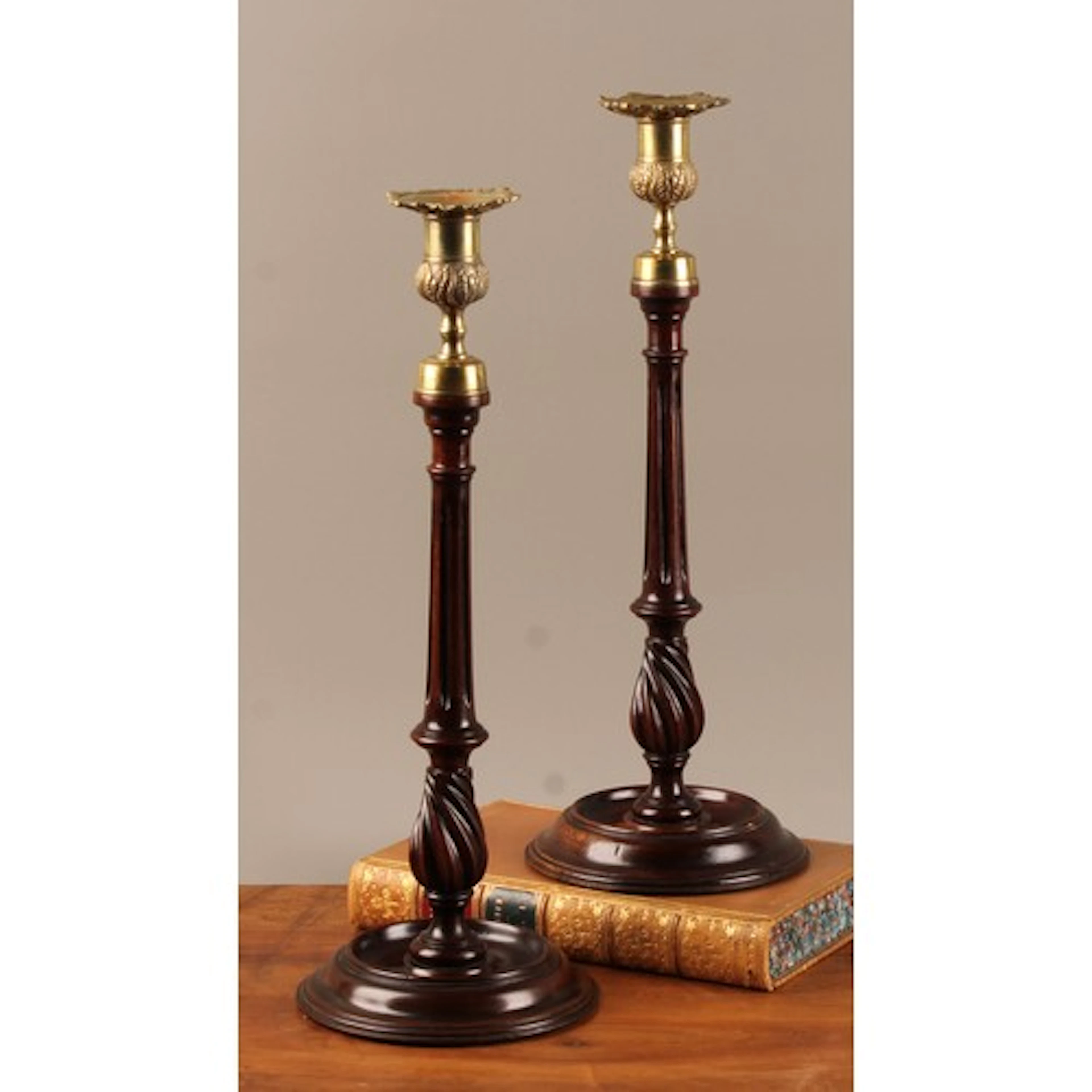 A pair of George III mahogany and brass mounted candlesticks...