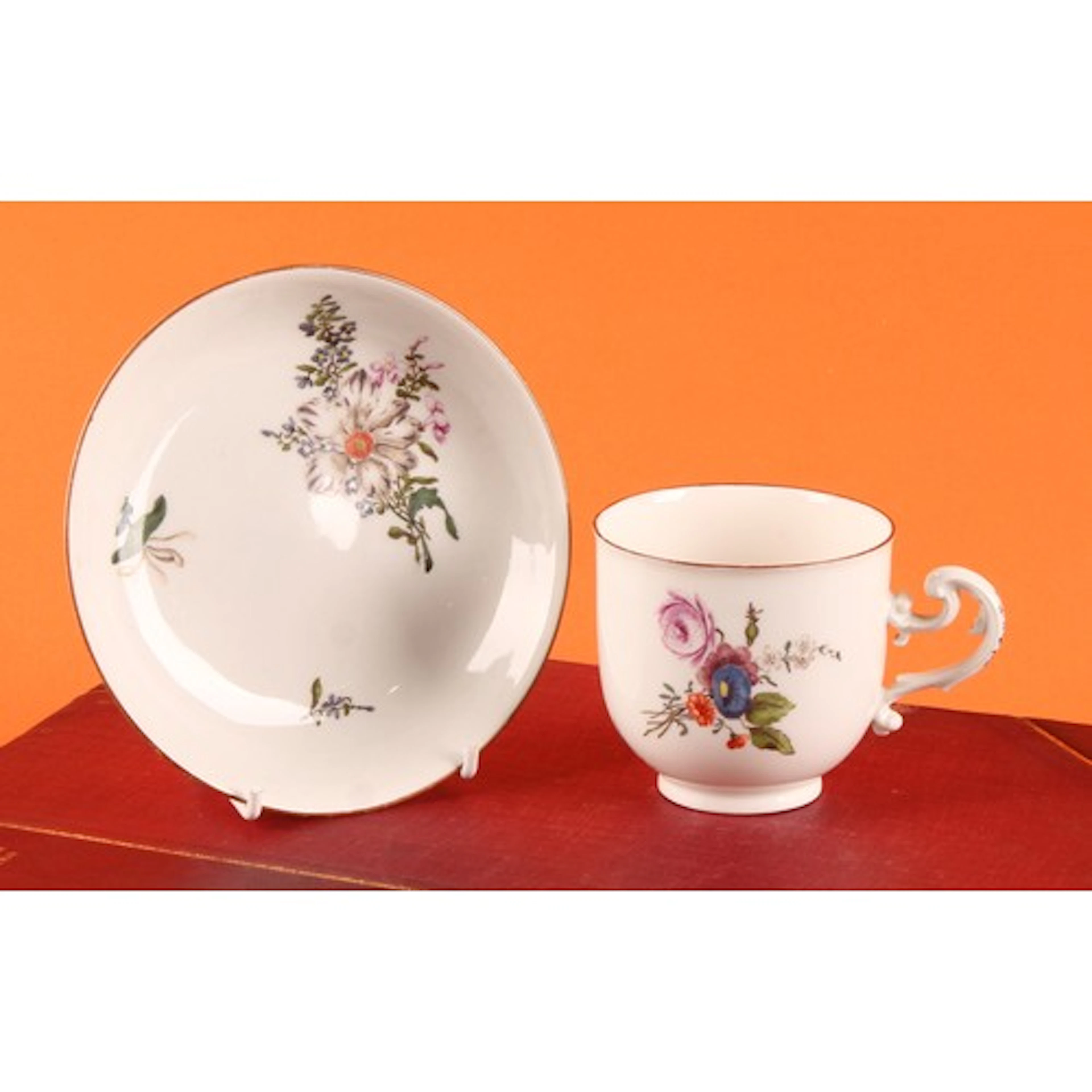 A Meissen coffee cup and saucer, painted with floral bouquet...