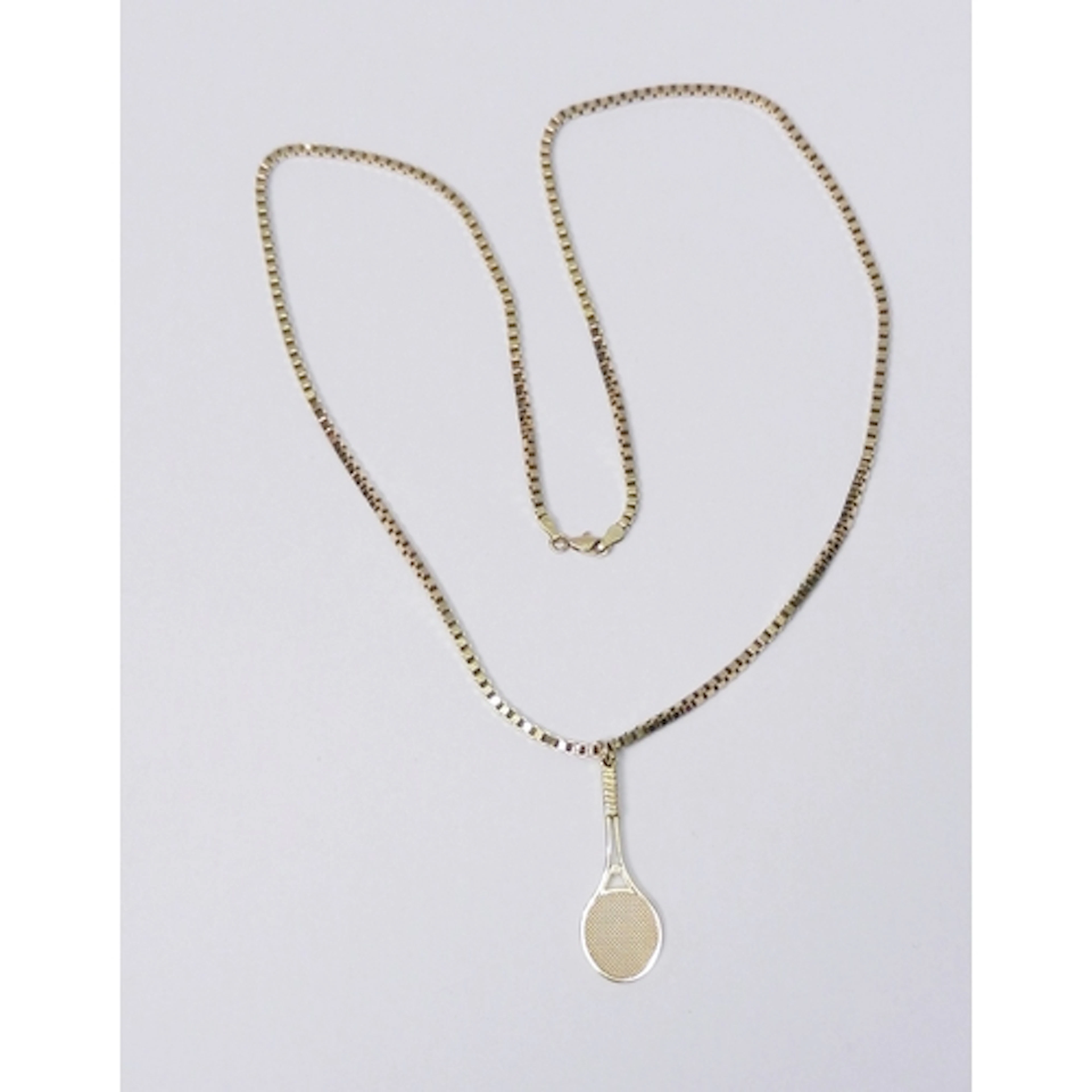 A tennis racket pendant 9ct gold, presented on a 9ct gold sq...