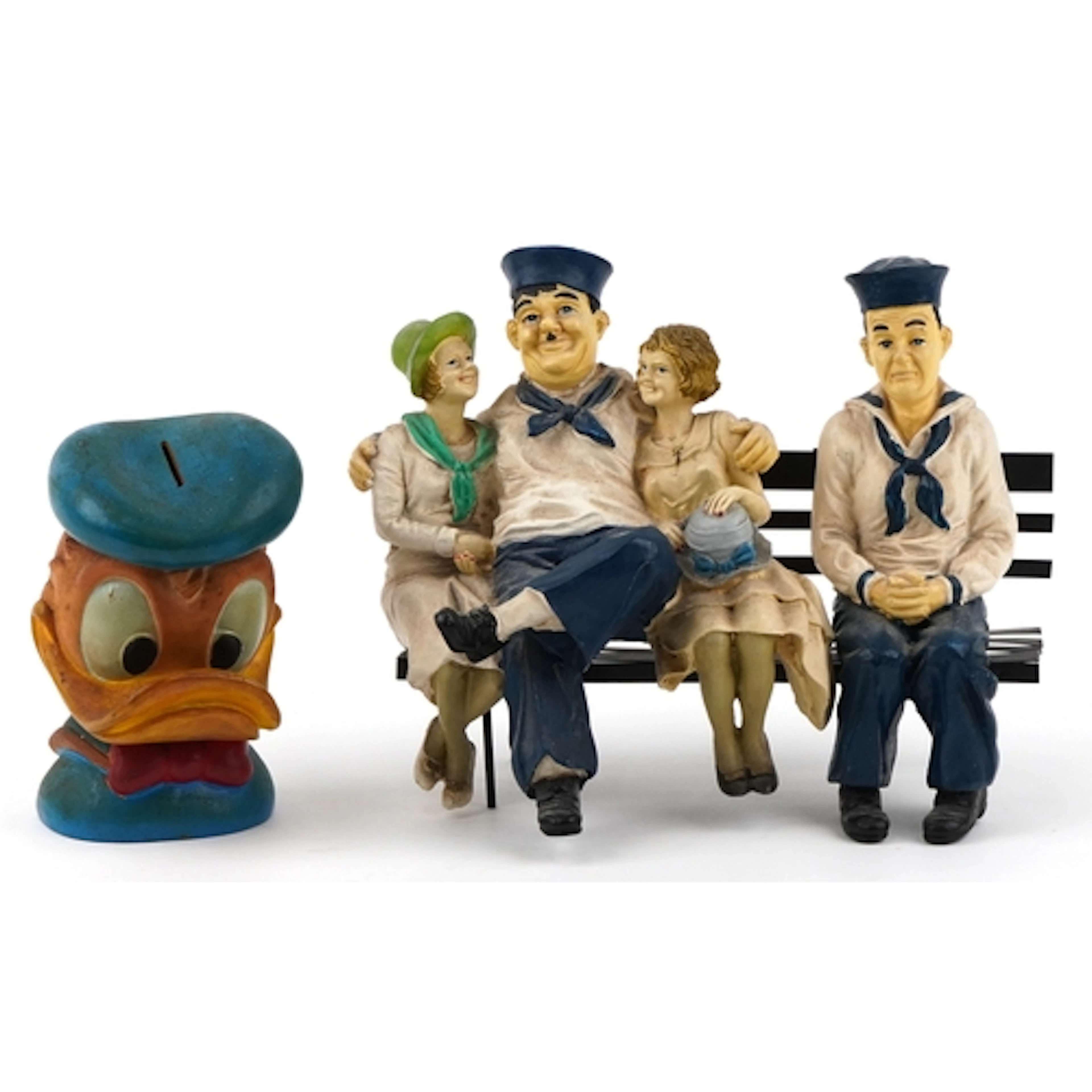 Pair of Laurel & Hardy figures on a park bench together with...