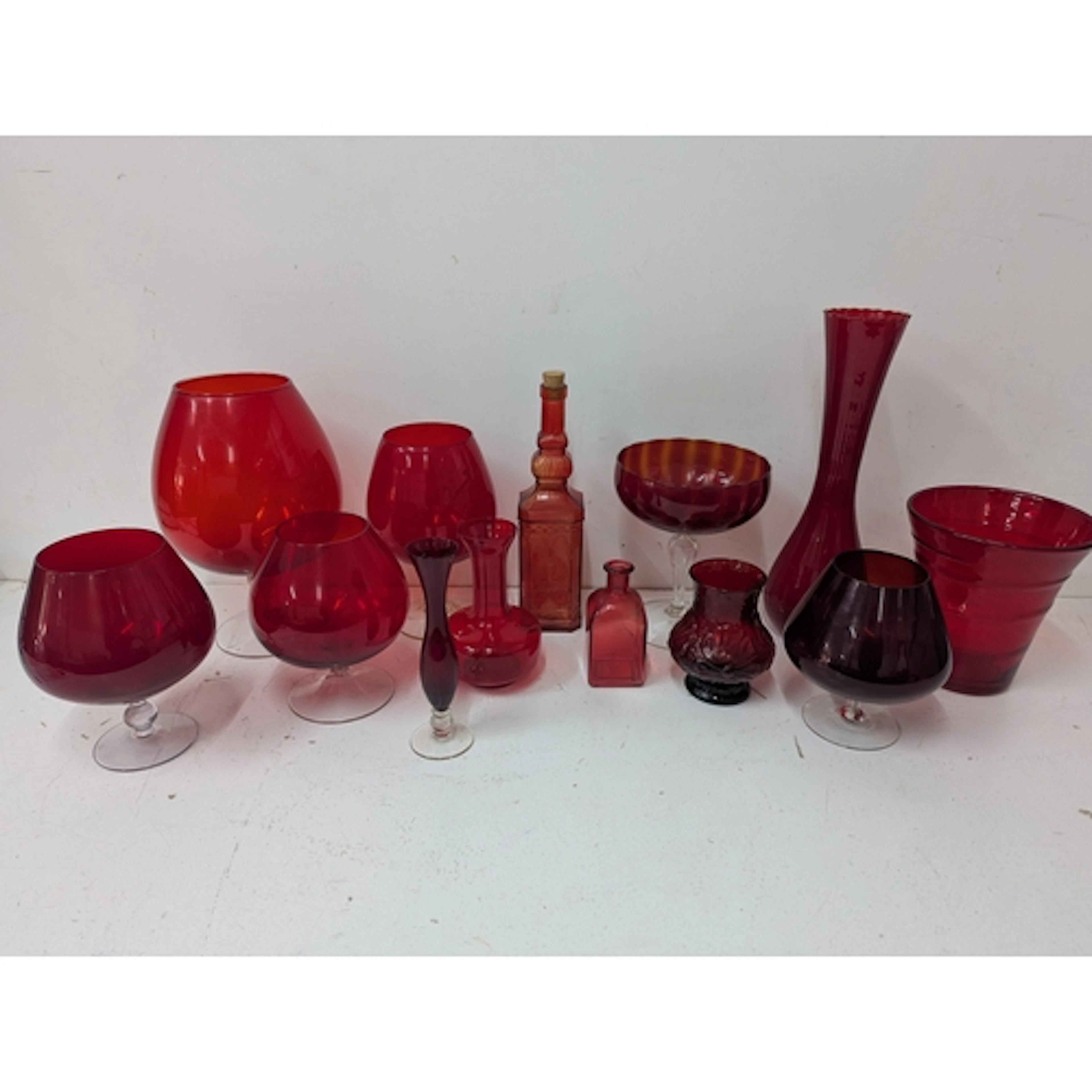 A group of red glass vases and a bottle to include a Whitefr...