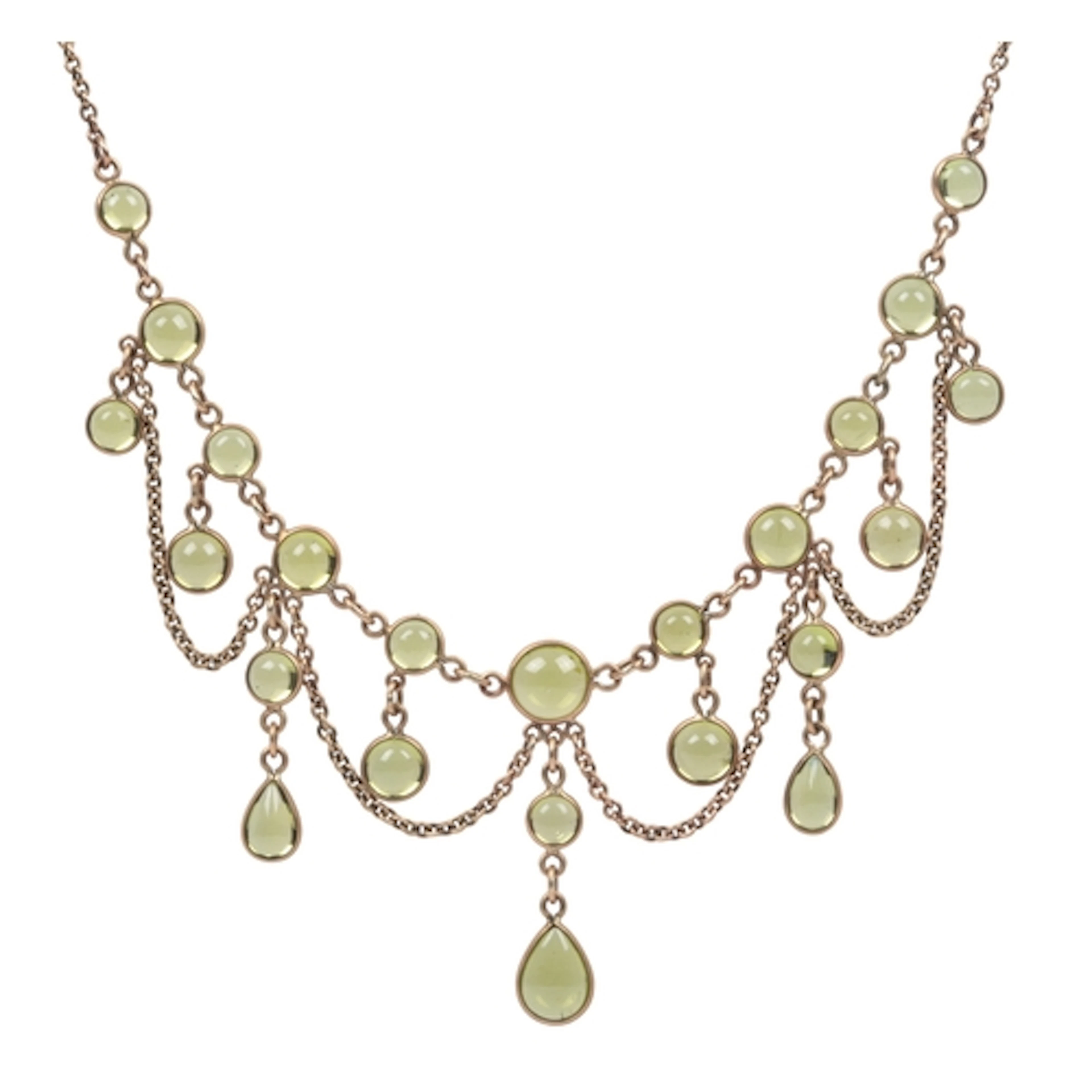 A gold and peridot necklace, of festoon design, set with a f...