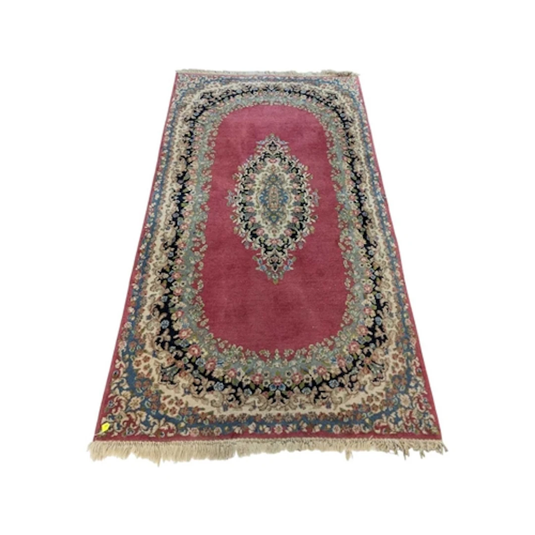 A 20th century Kirman Persian wool rug. The rug having rose ...