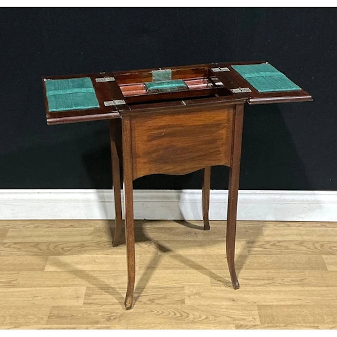 An early 20th century mahogany sewing table, hinged covers e...