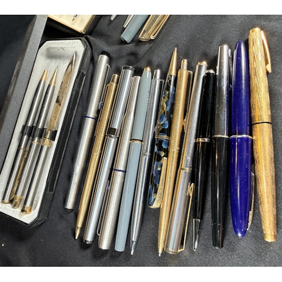 A selection of vintage fountain pens, biros and pencils