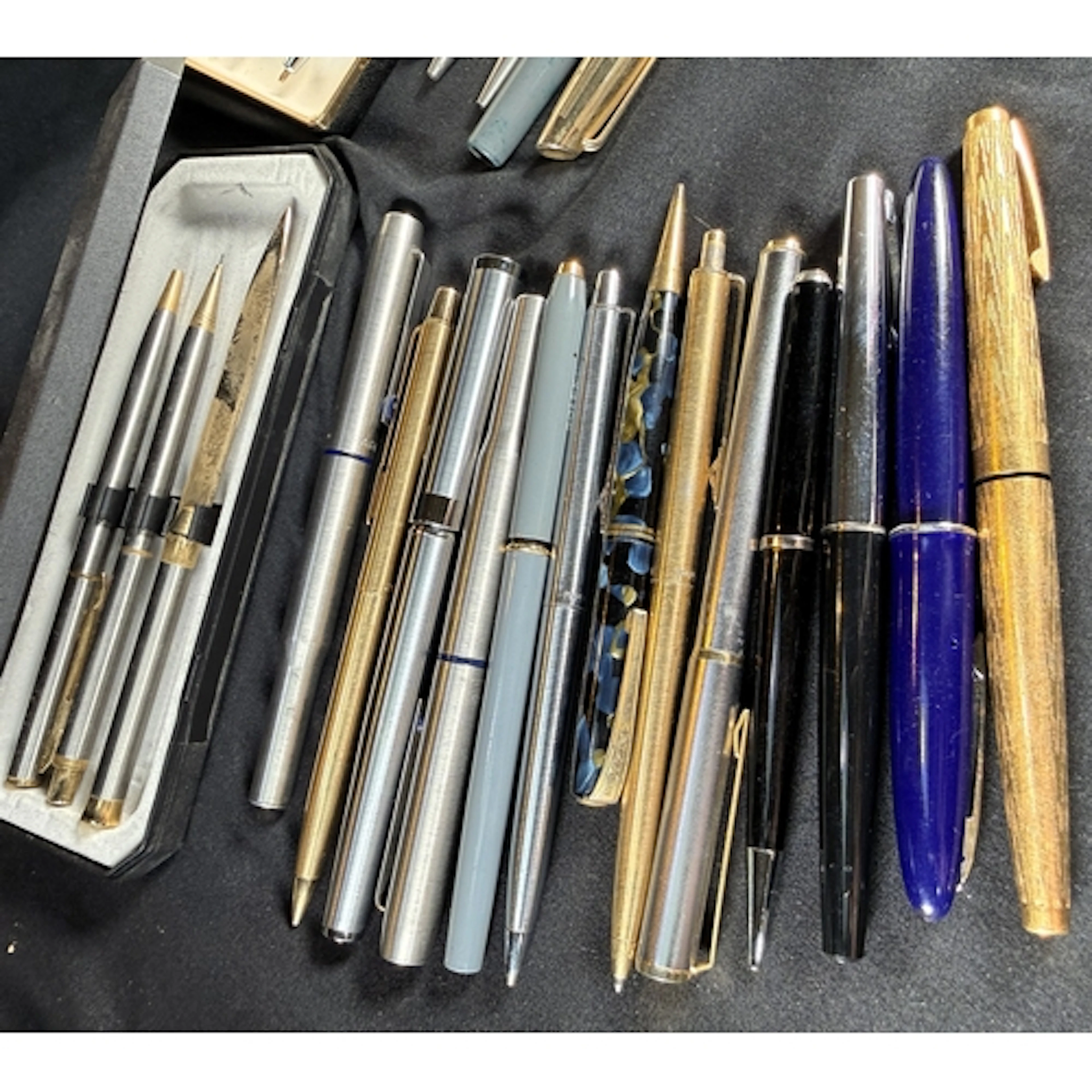 A selection of vintage fountain pens, biros and pencils